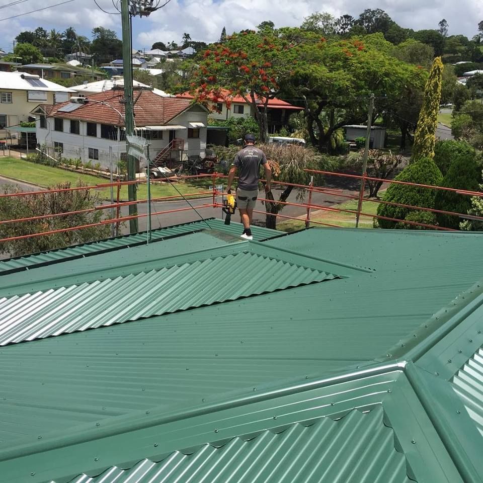 a man standing on top of a green roof