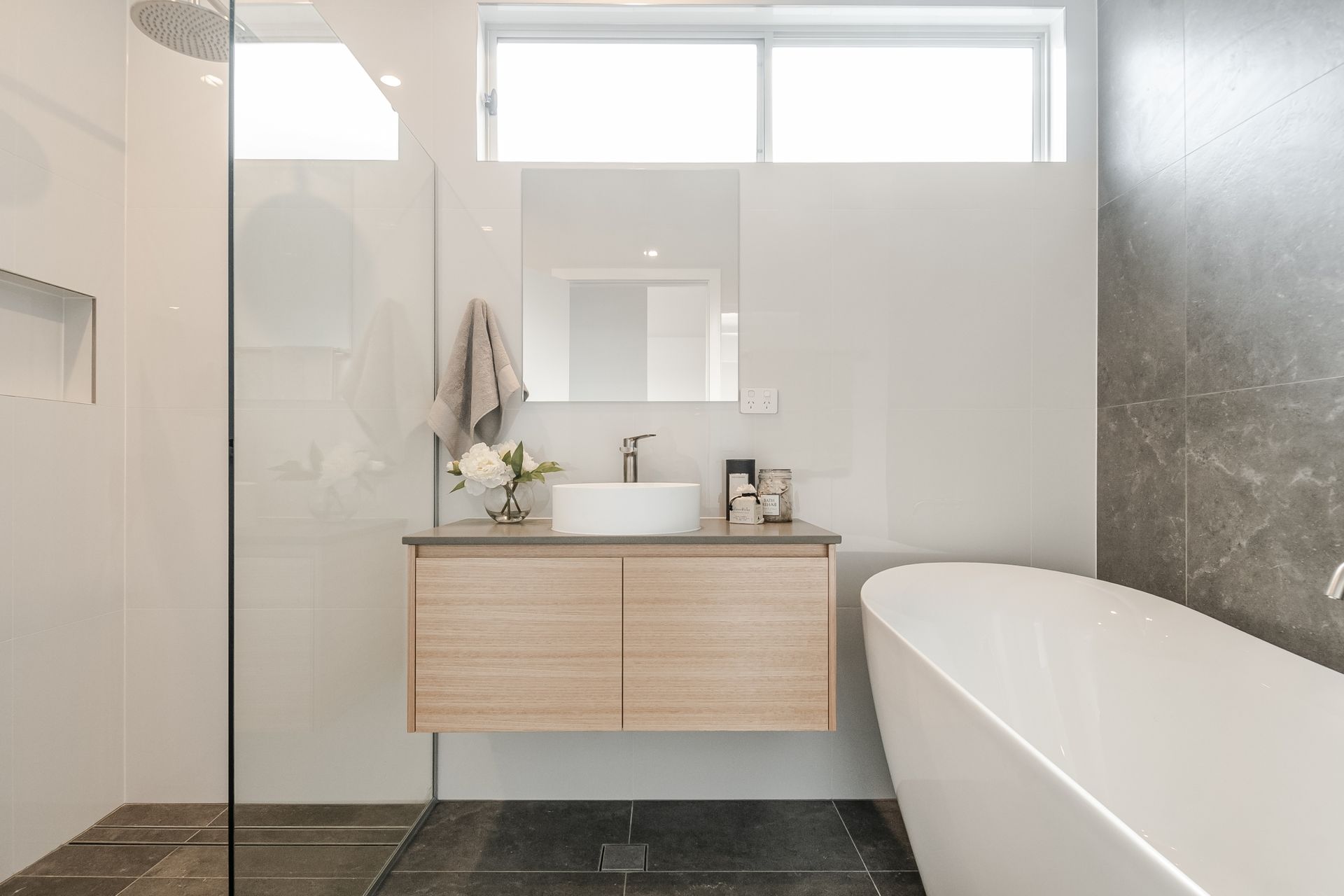 A bathroom with a sink , tub and shower.