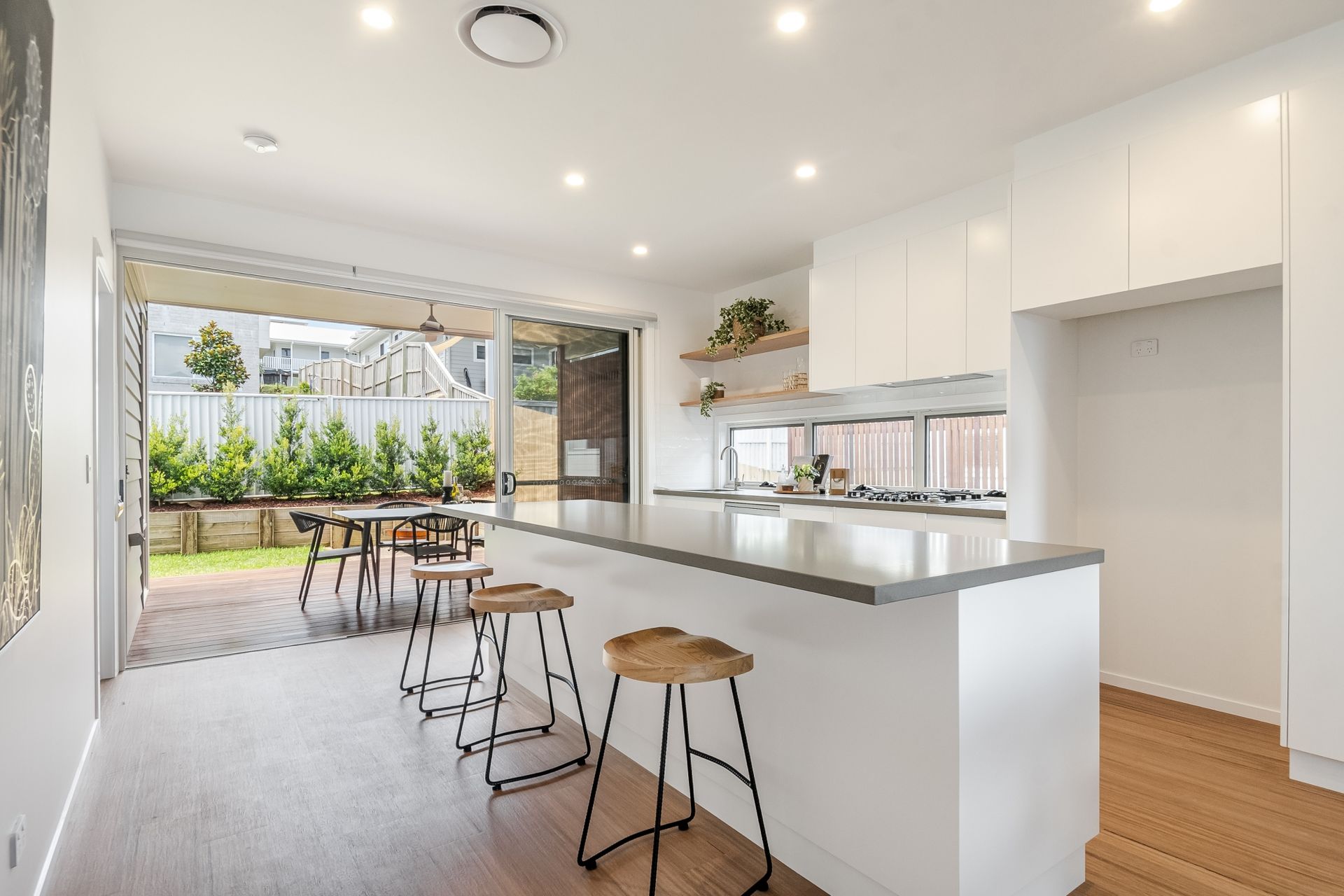 A kitchen with a long island and stools in a house.