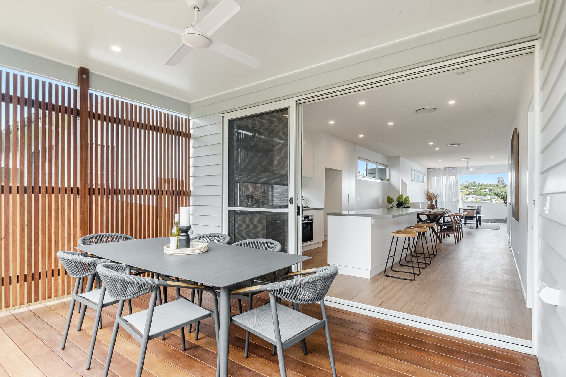 a patio with a table and chairs and a ceiling fan .