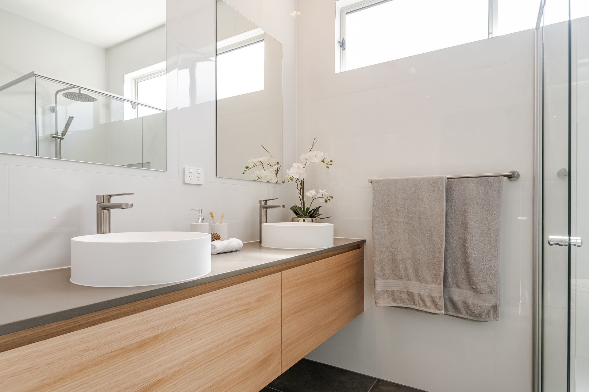 a bathroom with a sink , mirror and shower .