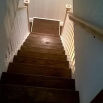 A kitchen with white cabinets , a stove , microwave , refrigerator and sink.