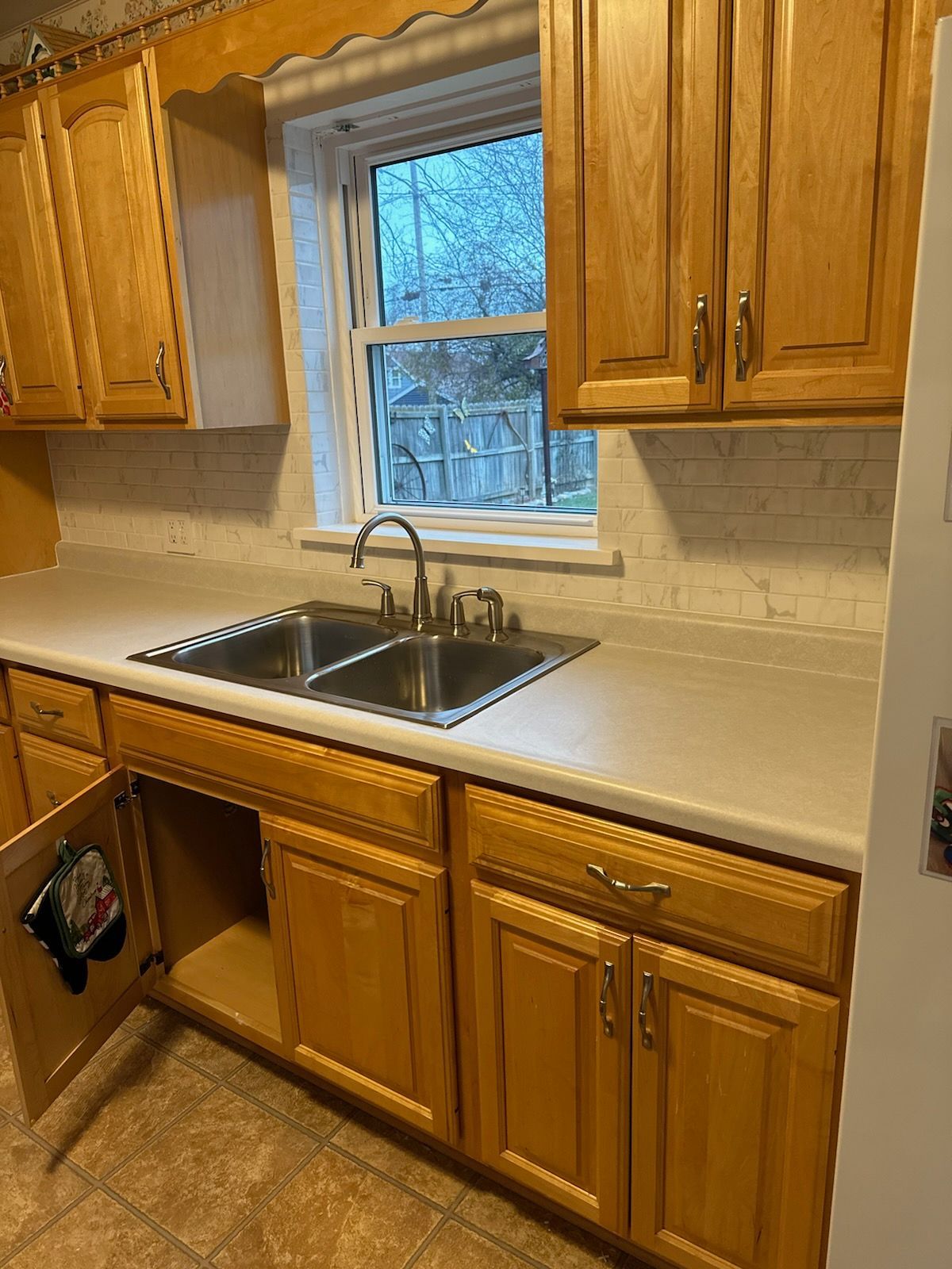 A wooden sliding barn door is hanging from the ceiling in a room.