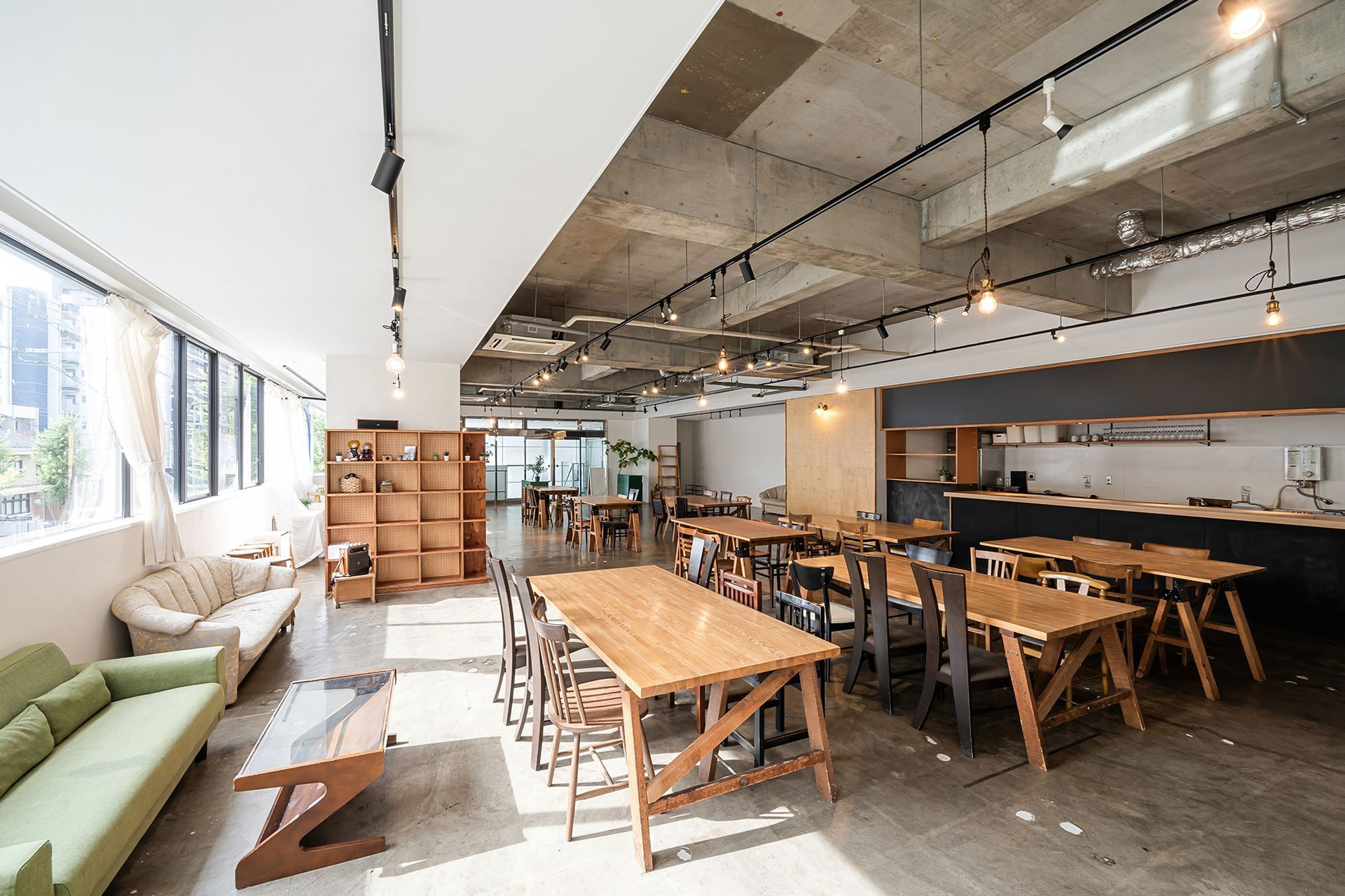 Industrial design with a kitchen area and large windows.