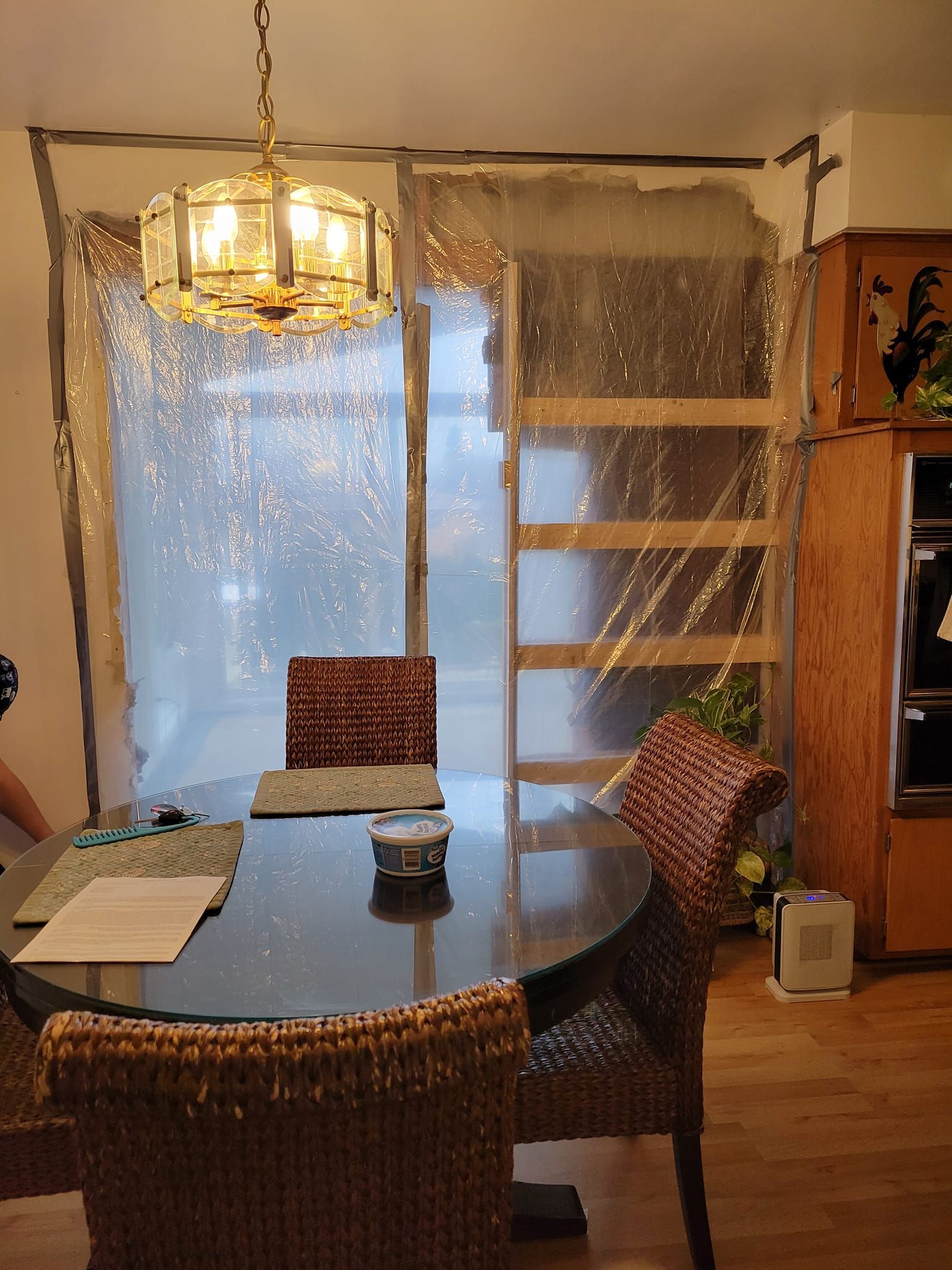 A dining room with a table and chairs and a chandelier hanging from the ceiling.