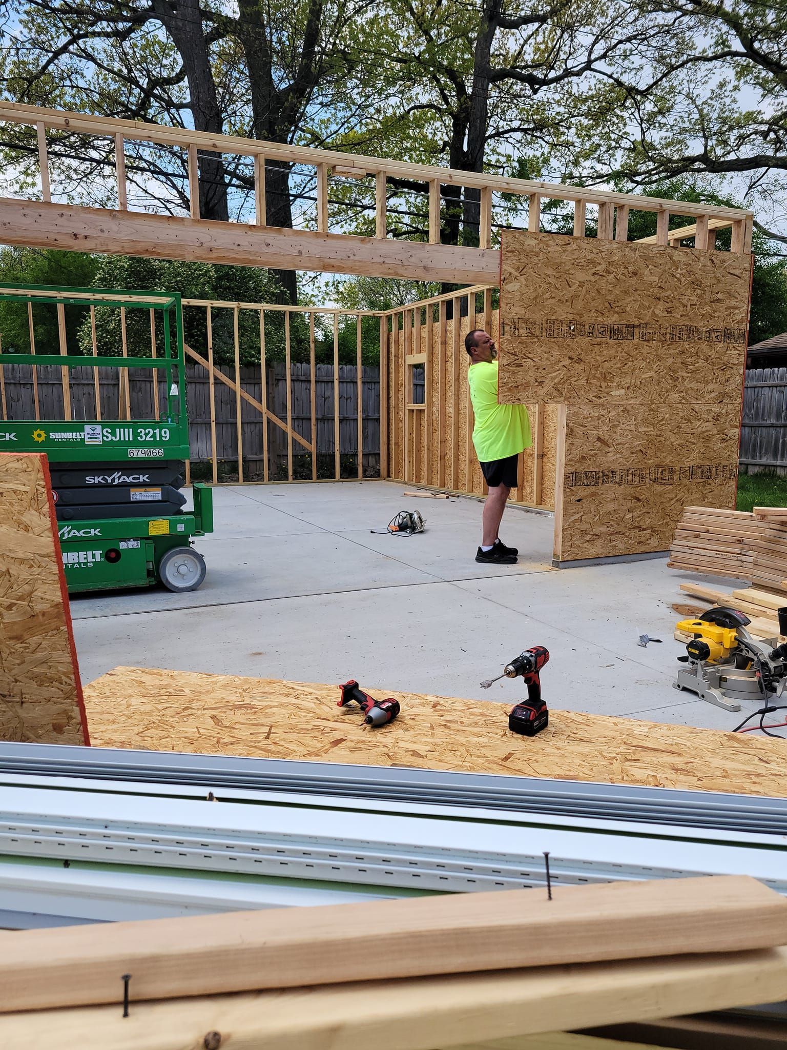 A man is standing in front of a building under construction.