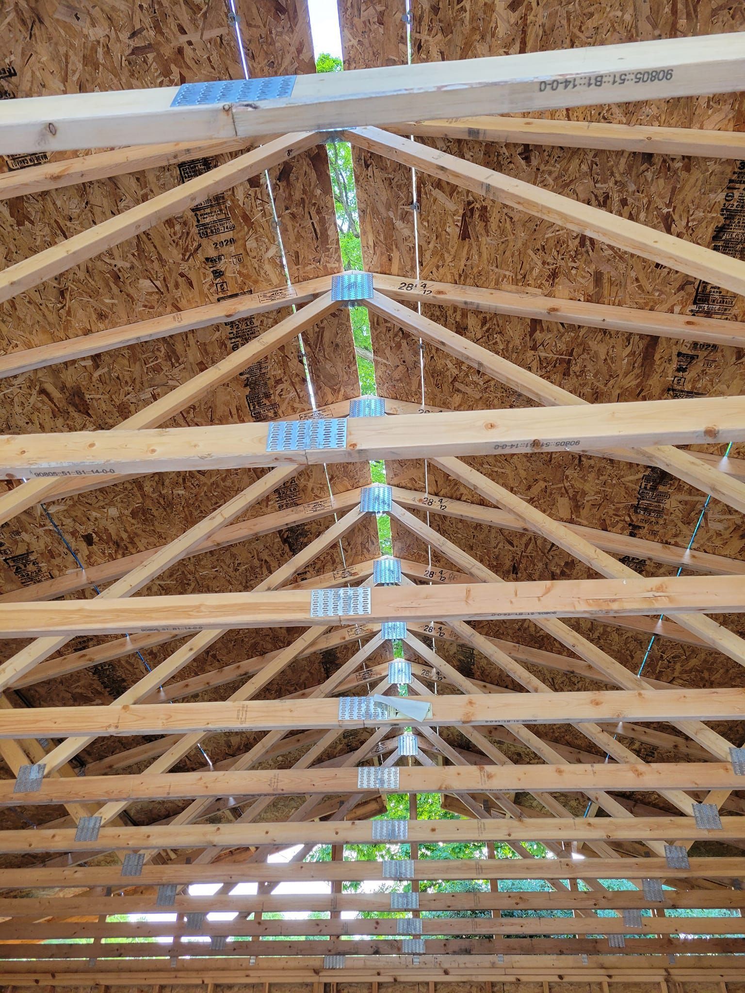 The ceiling of a building under construction with a lot of wooden beams.