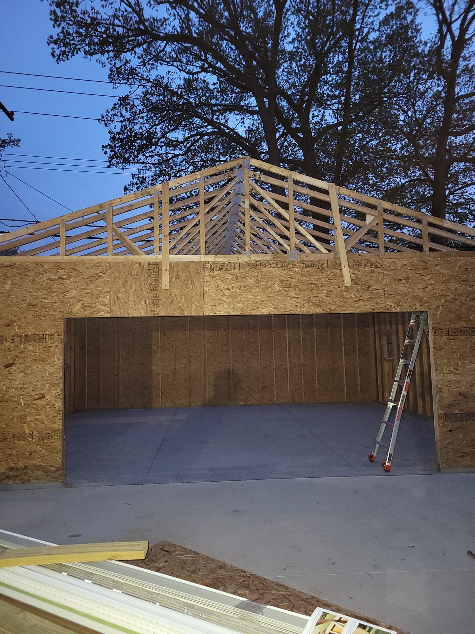 A ladder is sitting inside of a garage under construction