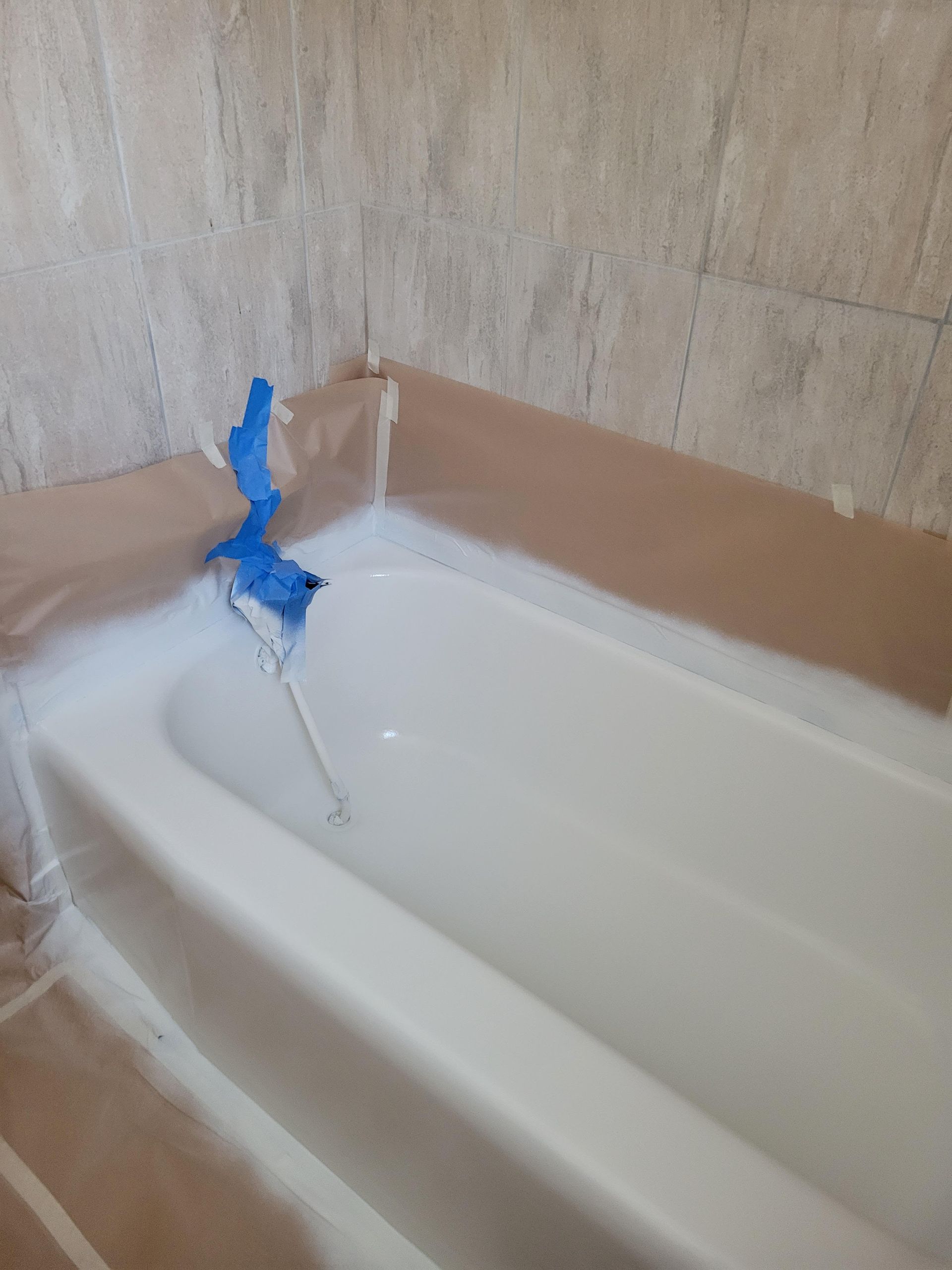 A bathtub is being painted in a bathroom.