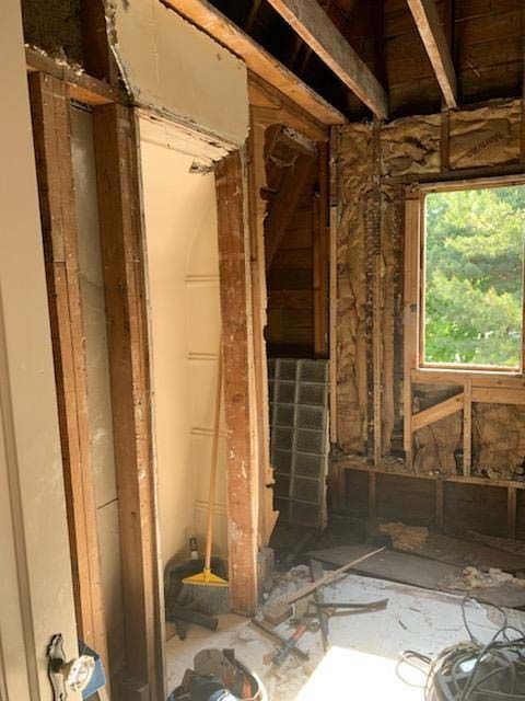 A room with a window and a broom in it.