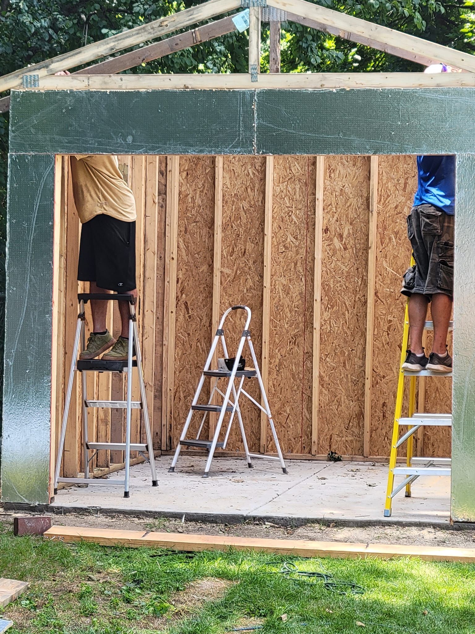 A group of people are working on a shed.
