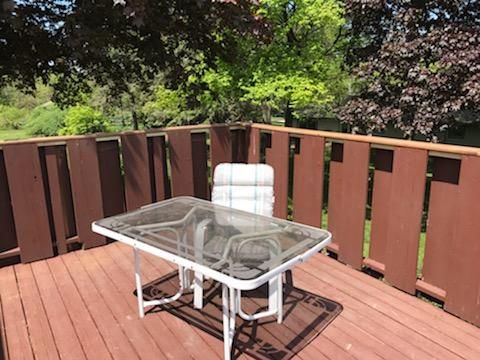 A wooden deck with a table and chairs on it.