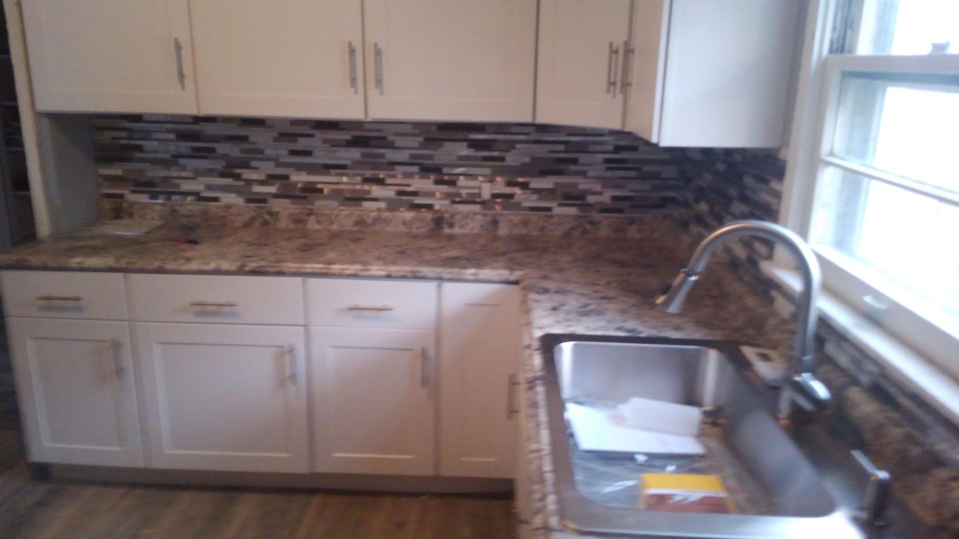 An empty room with a wooden floor and lots of windows.