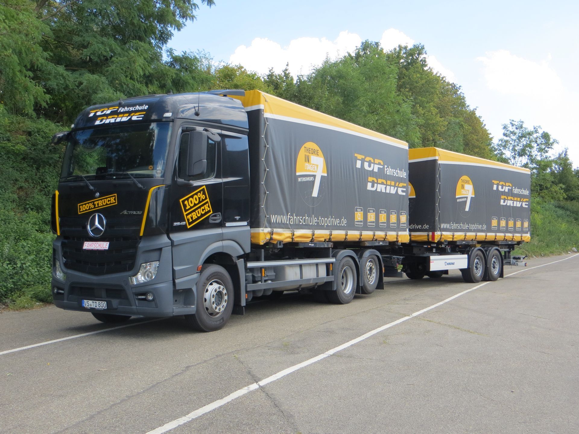 Zwei schwarze Autos stehen nebeneinander am Straßenrand.
