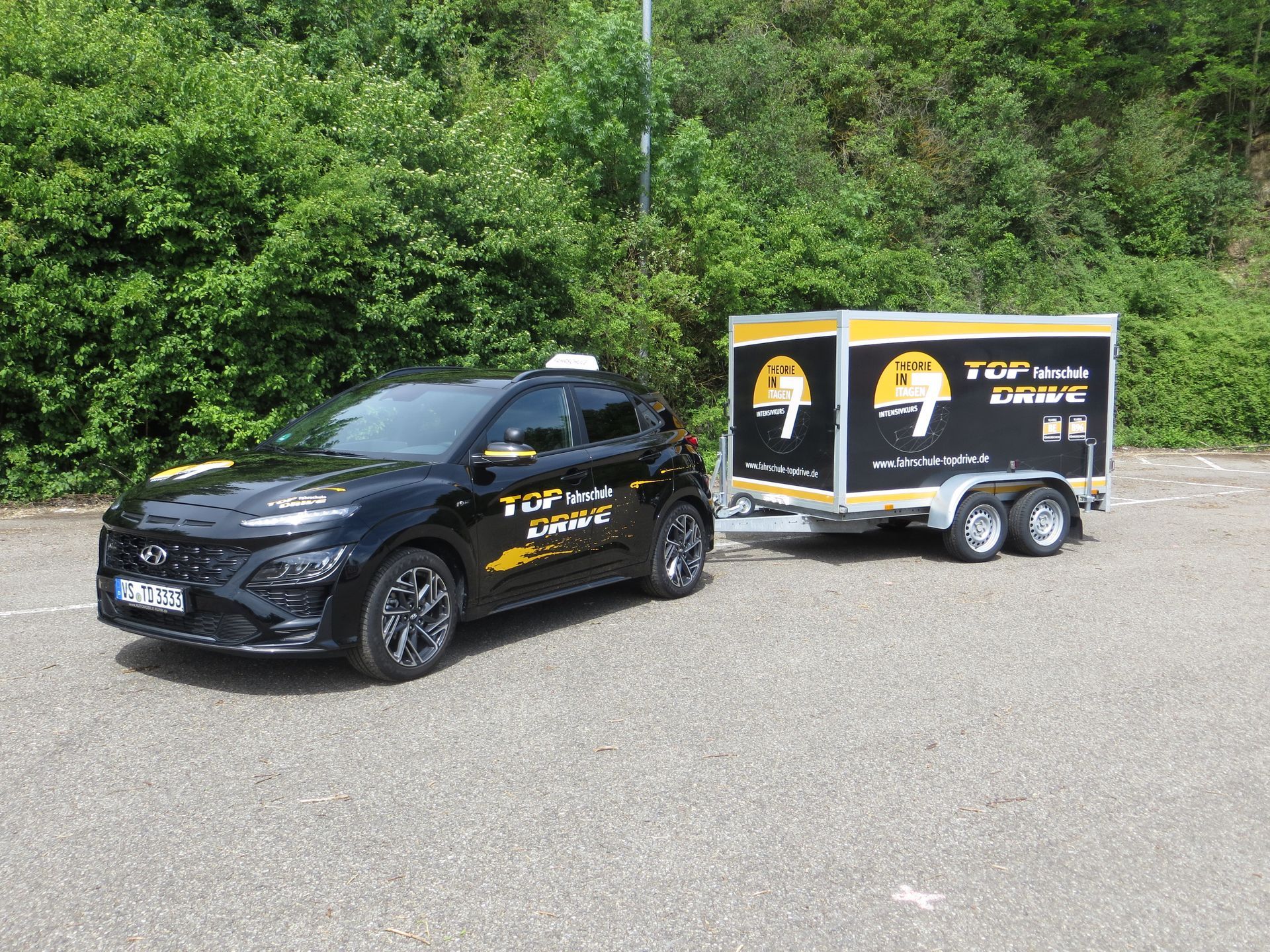 Zwei schwarze Autos stehen nebeneinander am Straßenrand.