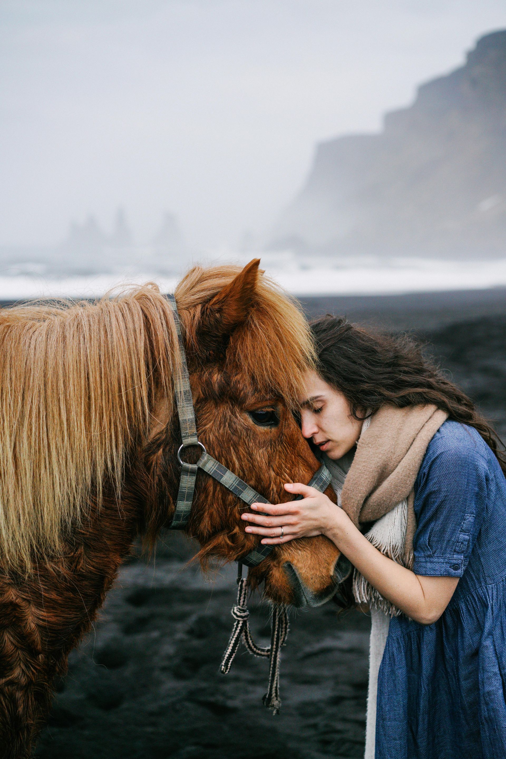 lady nuzzling her horse