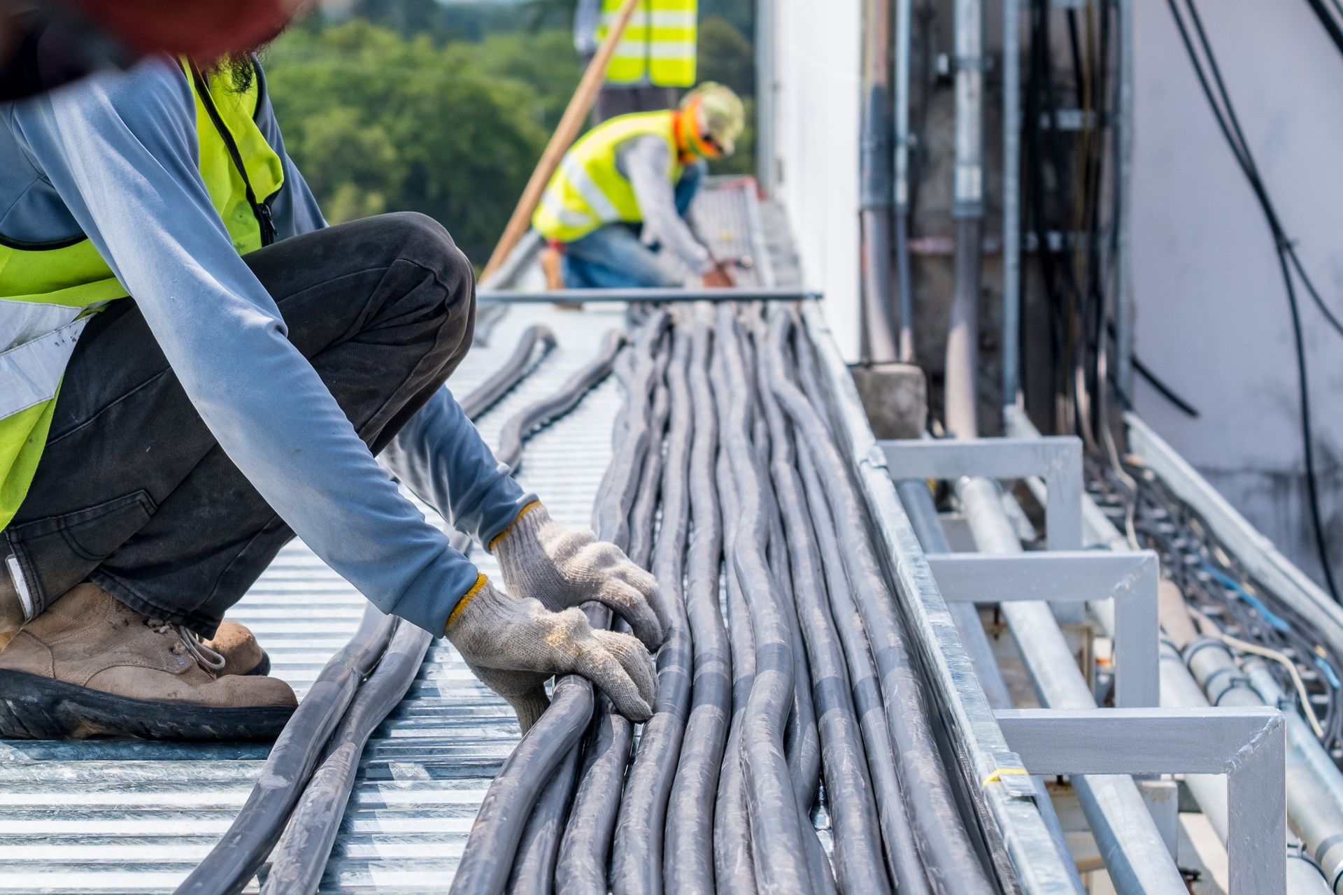 Worker handling bundled cables at a construction site