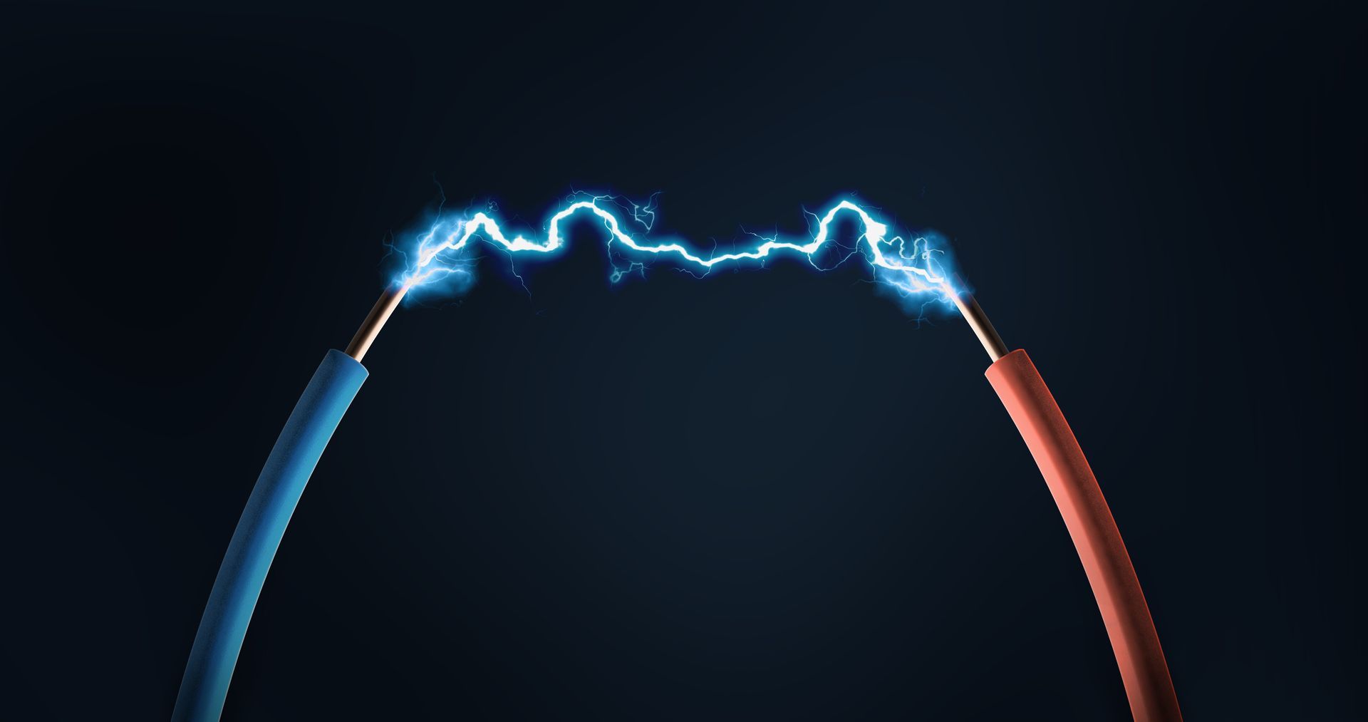 An electric arc jumps between the exposed ends of a blue and a red wire against a dark background.
