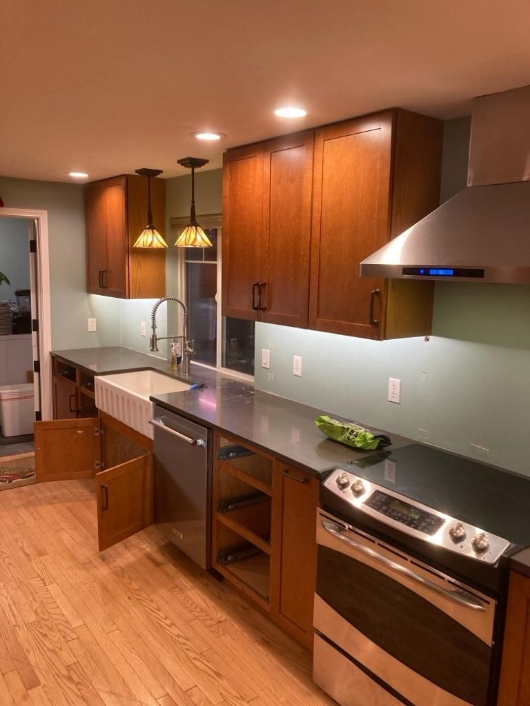 Modern kitchen with wood cabinets, stainless steel appliances, and hardwood floors