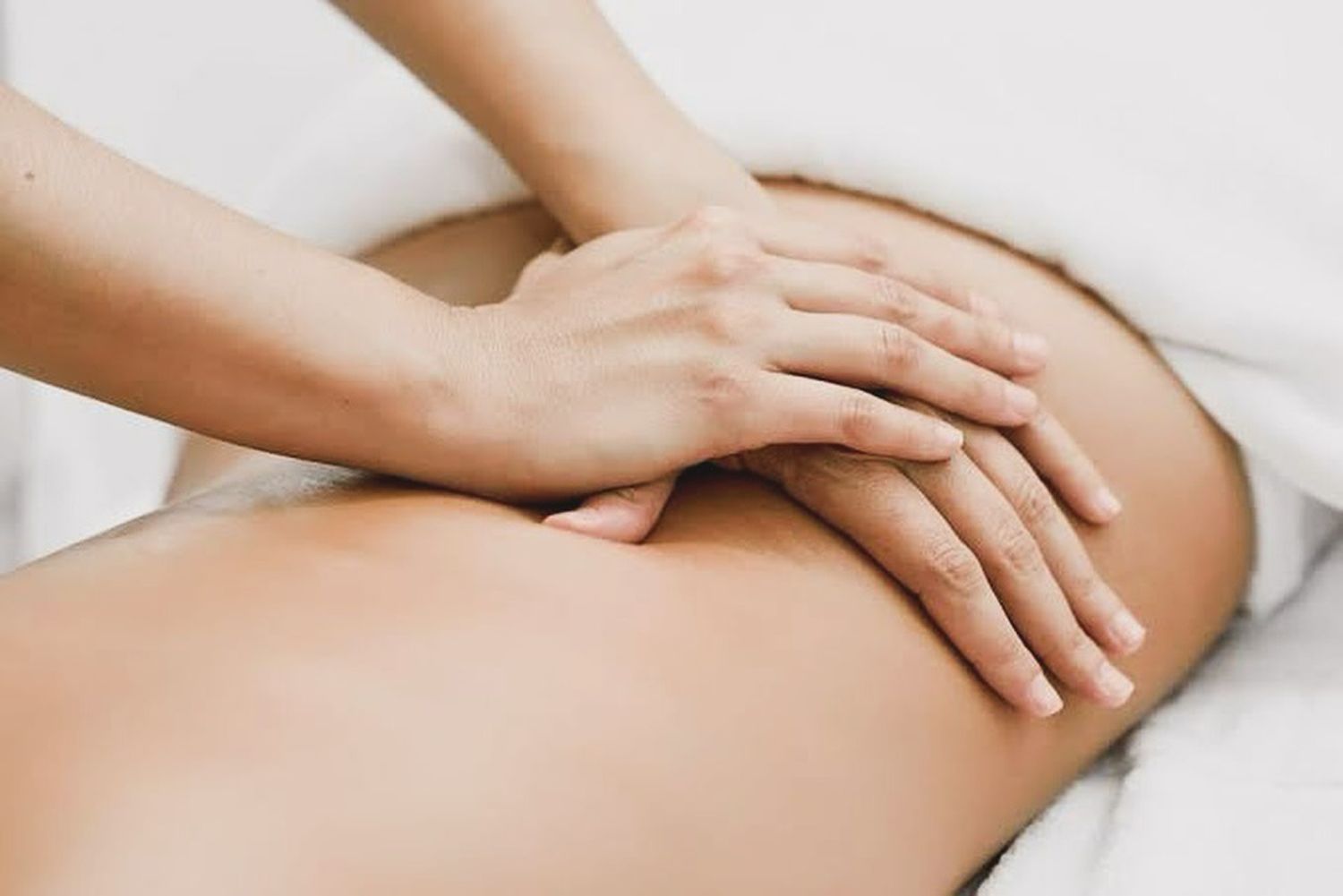 Hands Massaging a Person's Lower Back on A Massage Table — My Chiropractor Mackay City in Mackay, QLD