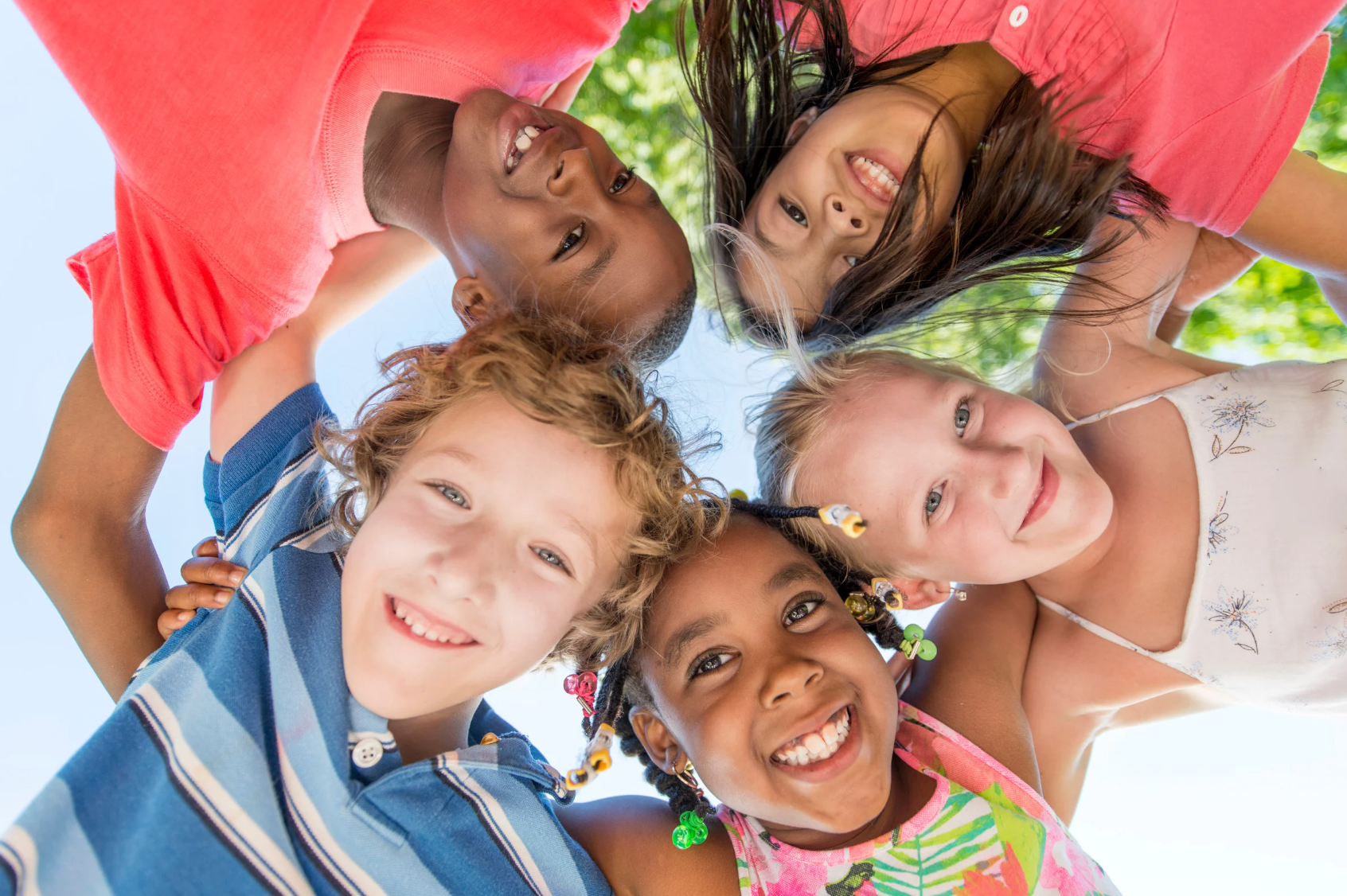 A group of children are standing in a circle and smiling. Eden Creative Arts - Private Christian Micro School
