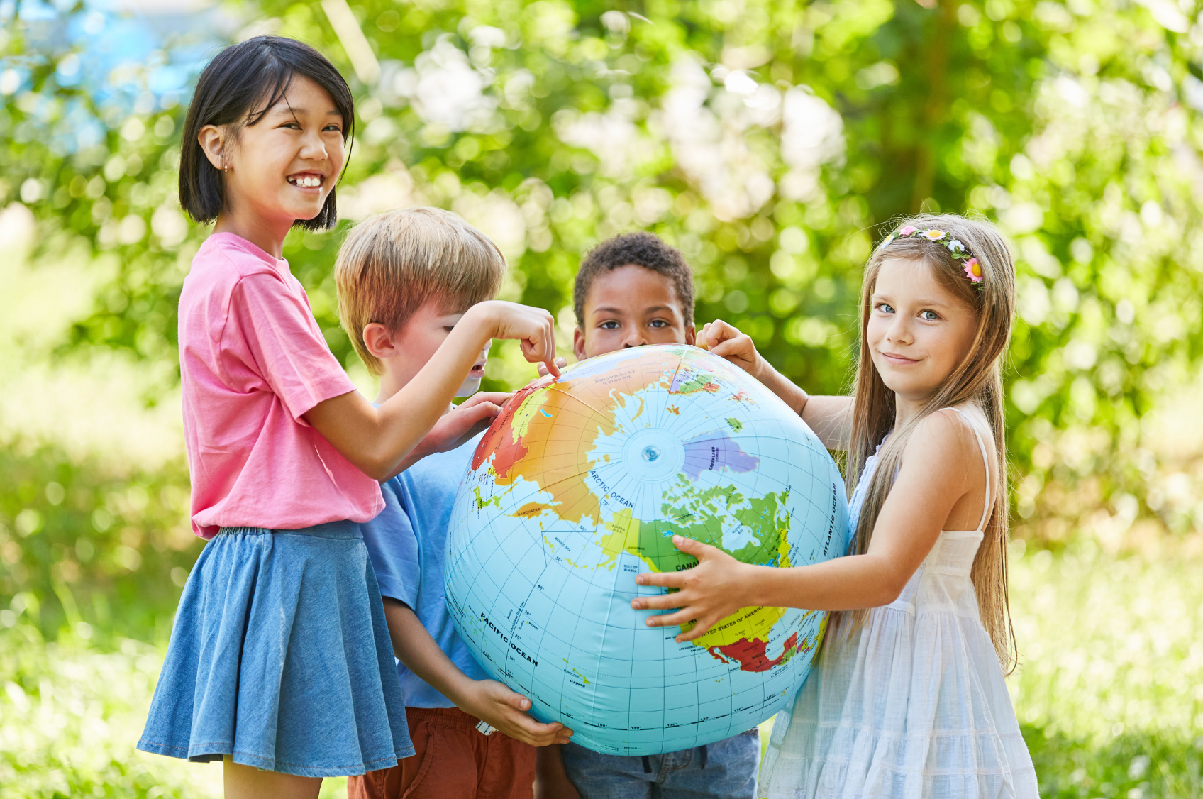 A group of children are holding a globe in their hands. Eden Creative Arts - Private Christian Micro School
