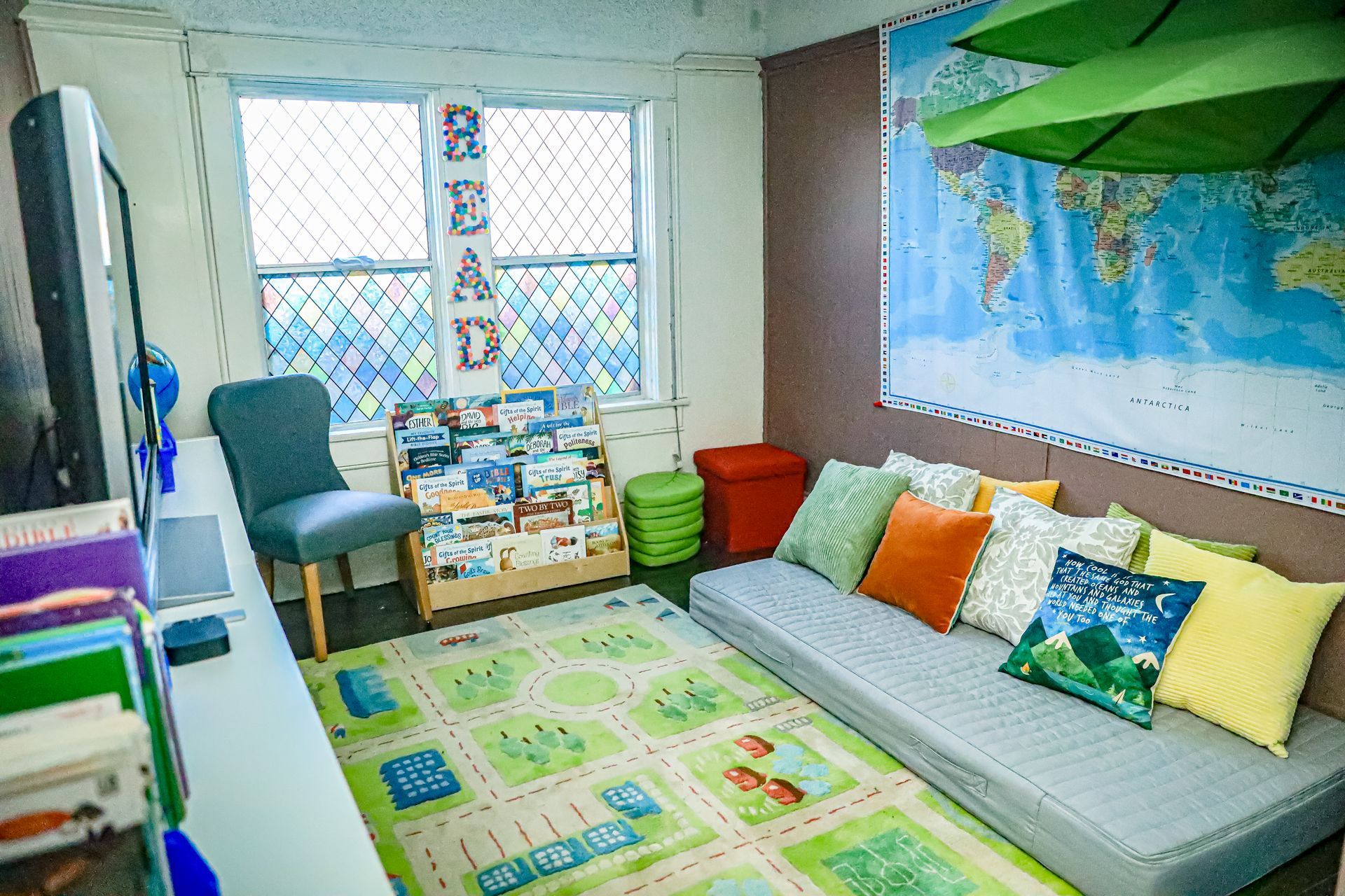 A young girl is peeking out from behind a bookshelf in a library.