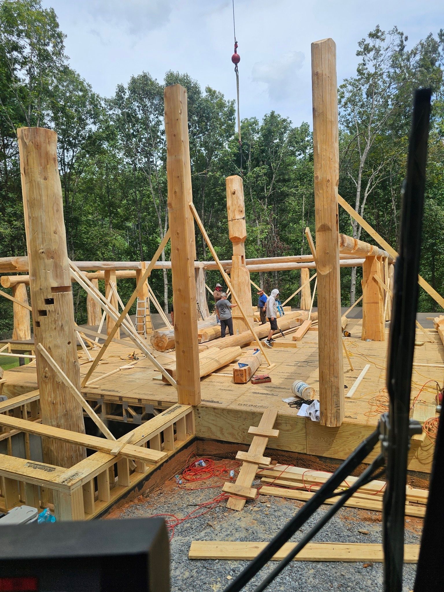 A large wooden structure is being built with a crane.