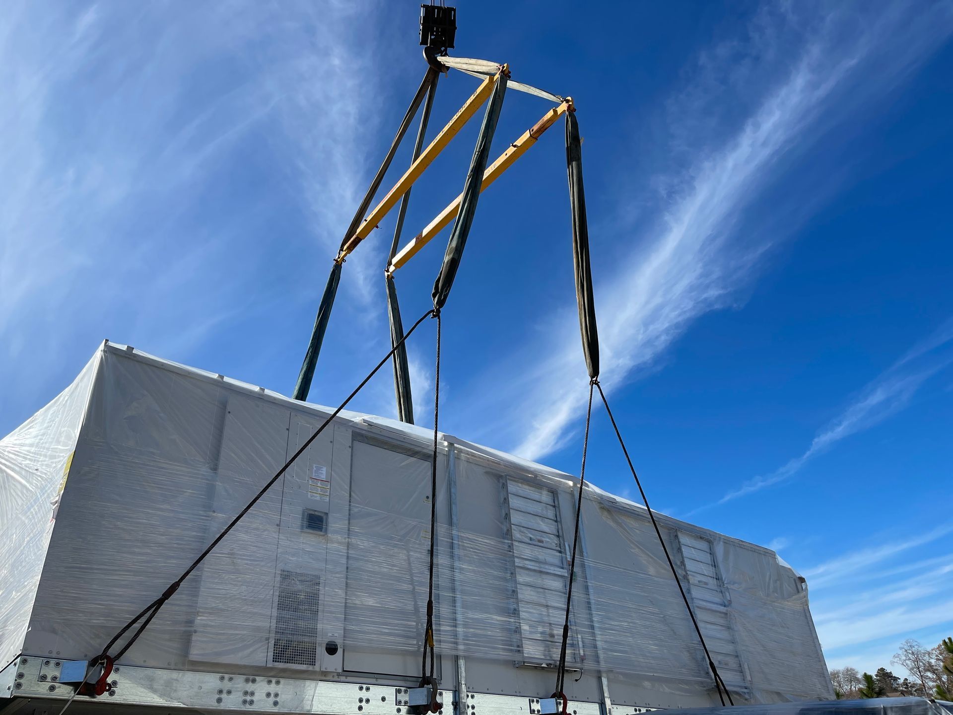 A large concrete block is being lifted by a crane