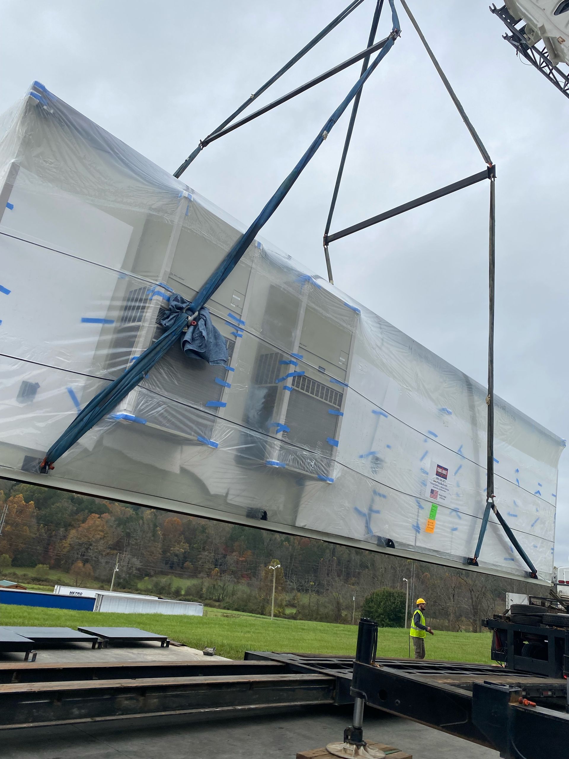 A large piece of plastic is being lifted by a crane.