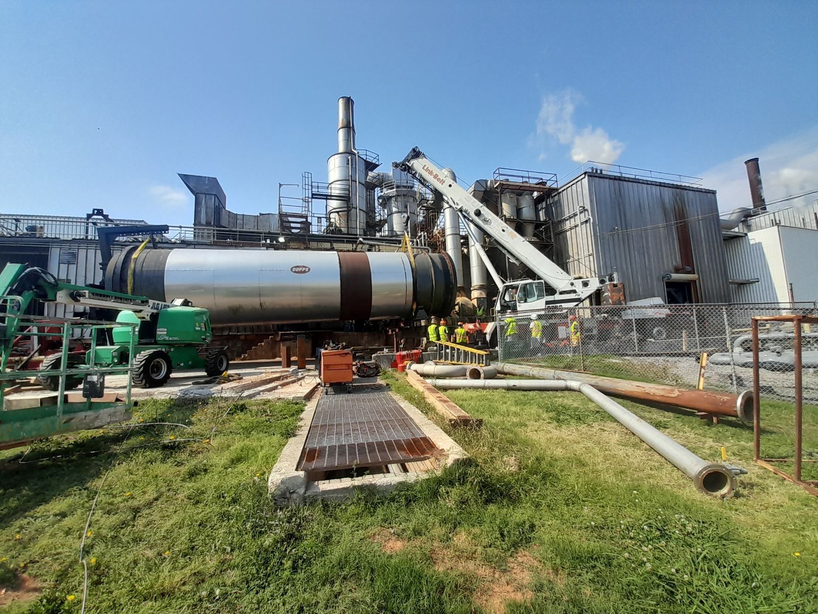 A large industrial plant with a lot of pipes in front of it.