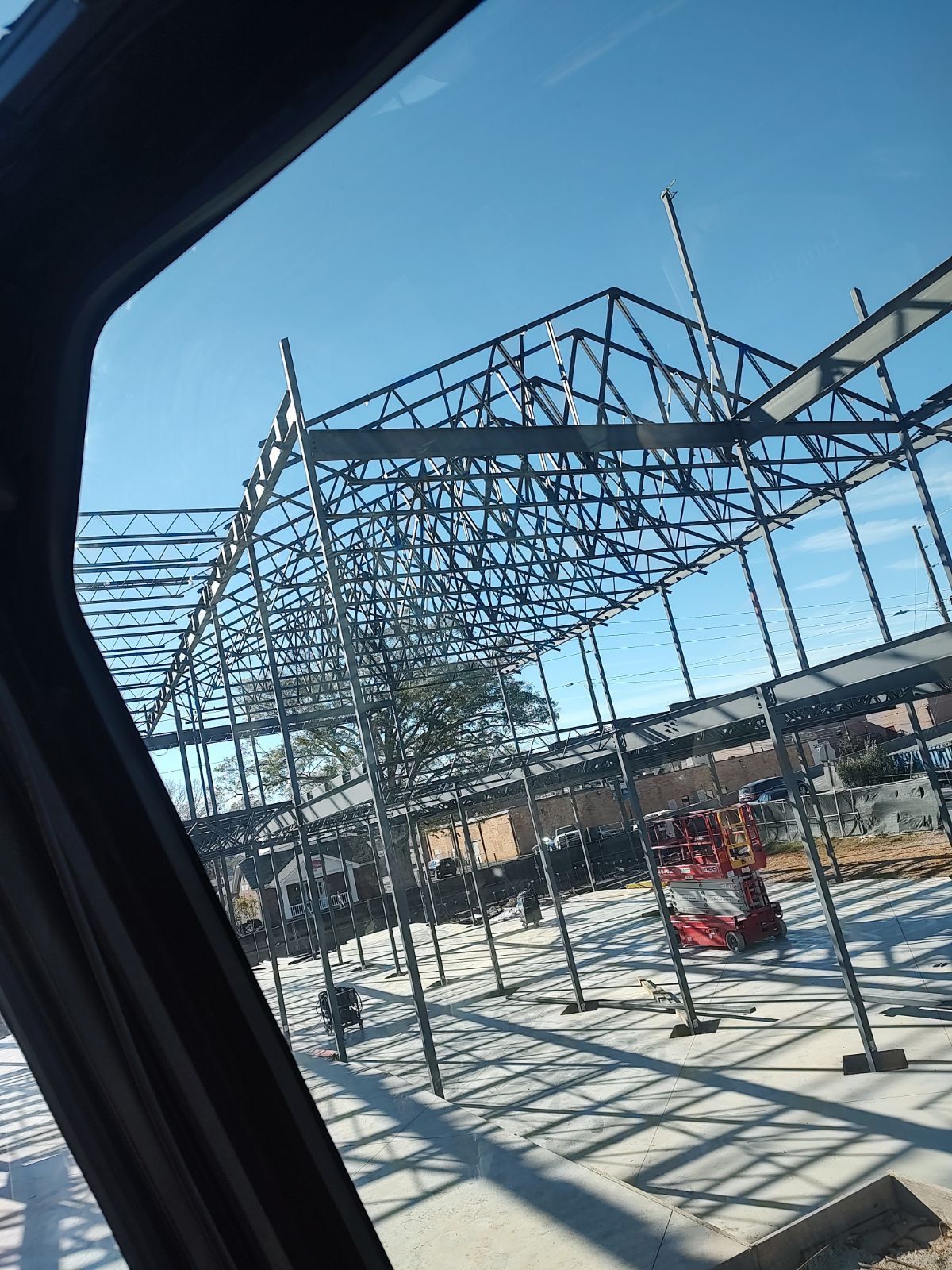 A large metal structure is being built on a construction site.