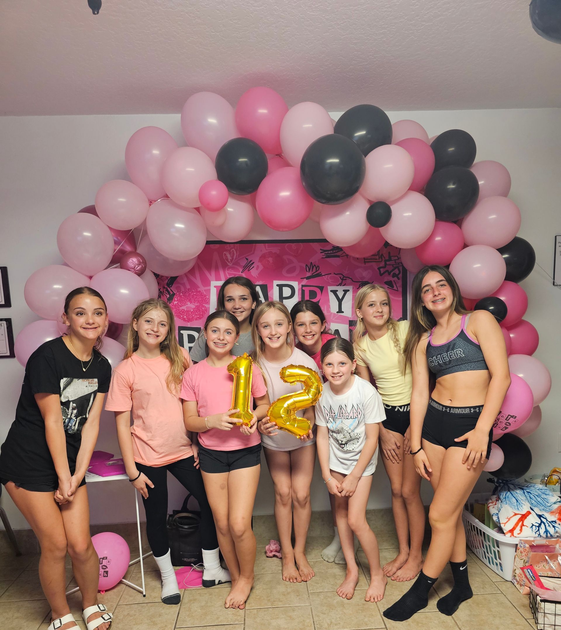 A group of people are posing for a picture in front of balloons.