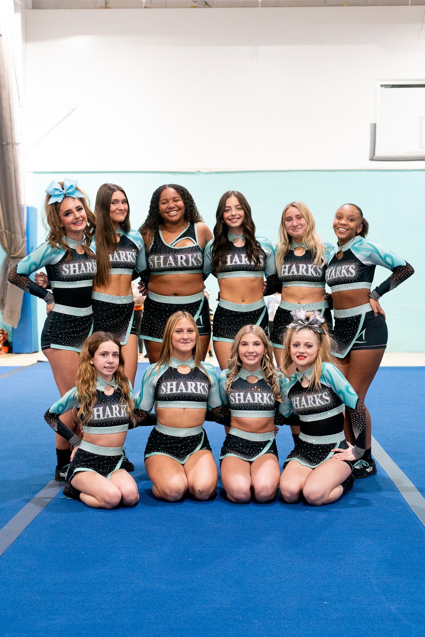 A group of cheerleaders for the florida elite sharks are posing for a picture.