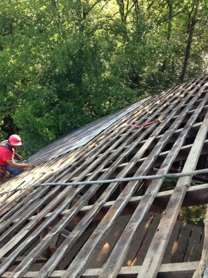 A man is working on the roof of a building.