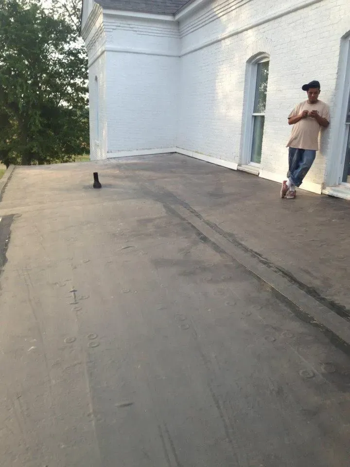 A man is standing on the roof of a building.