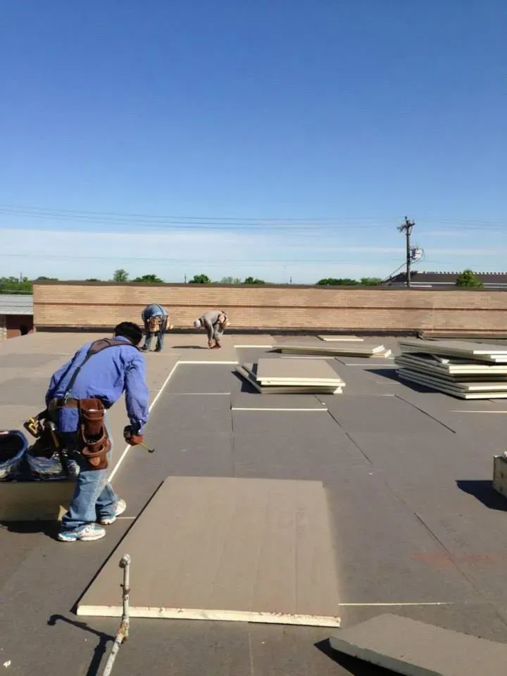 A man is measuring a piece of wood on a roof