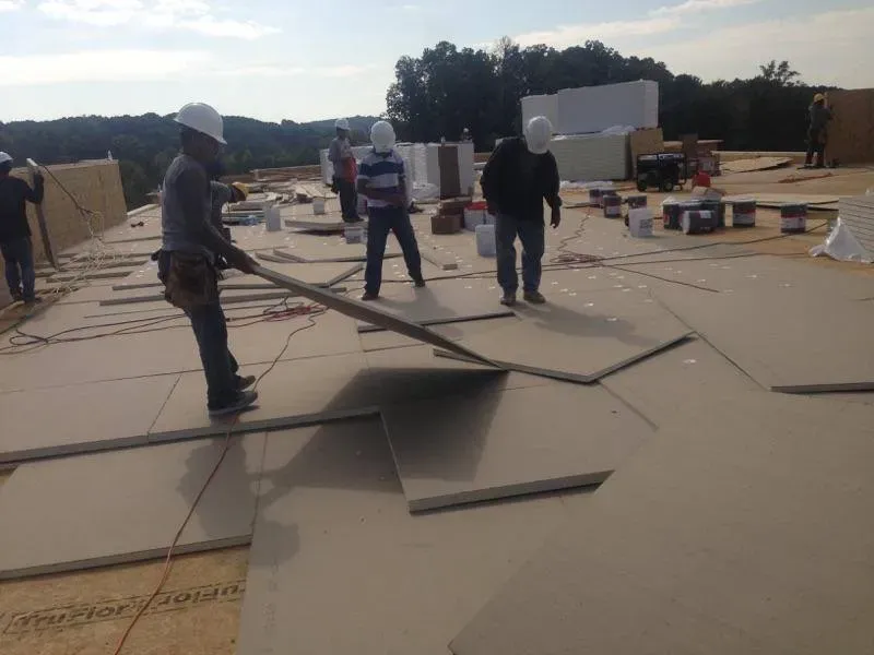 A group of construction workers are working on a roof