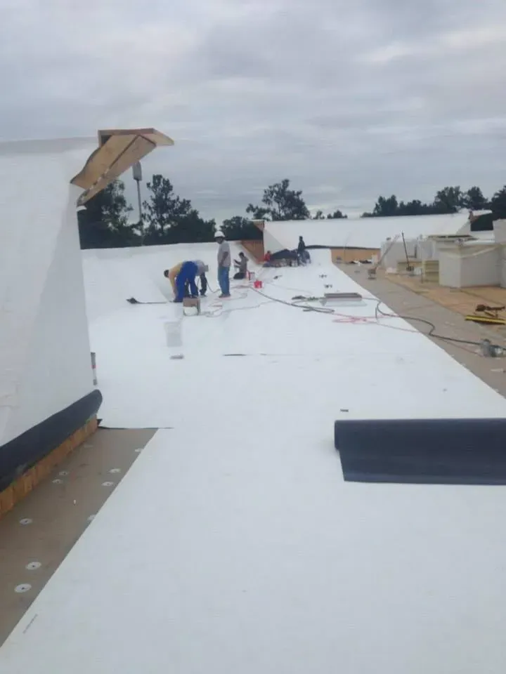 A group of people are working on a white roof