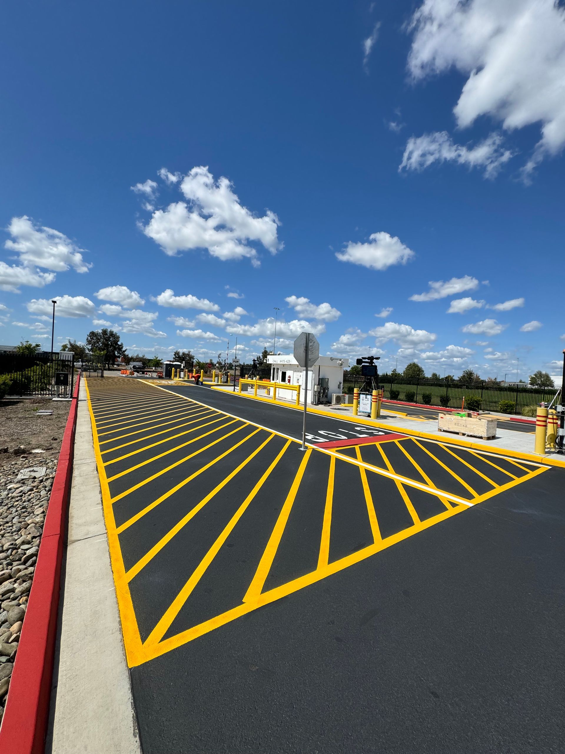 A road with yellow lines on it and a red curb