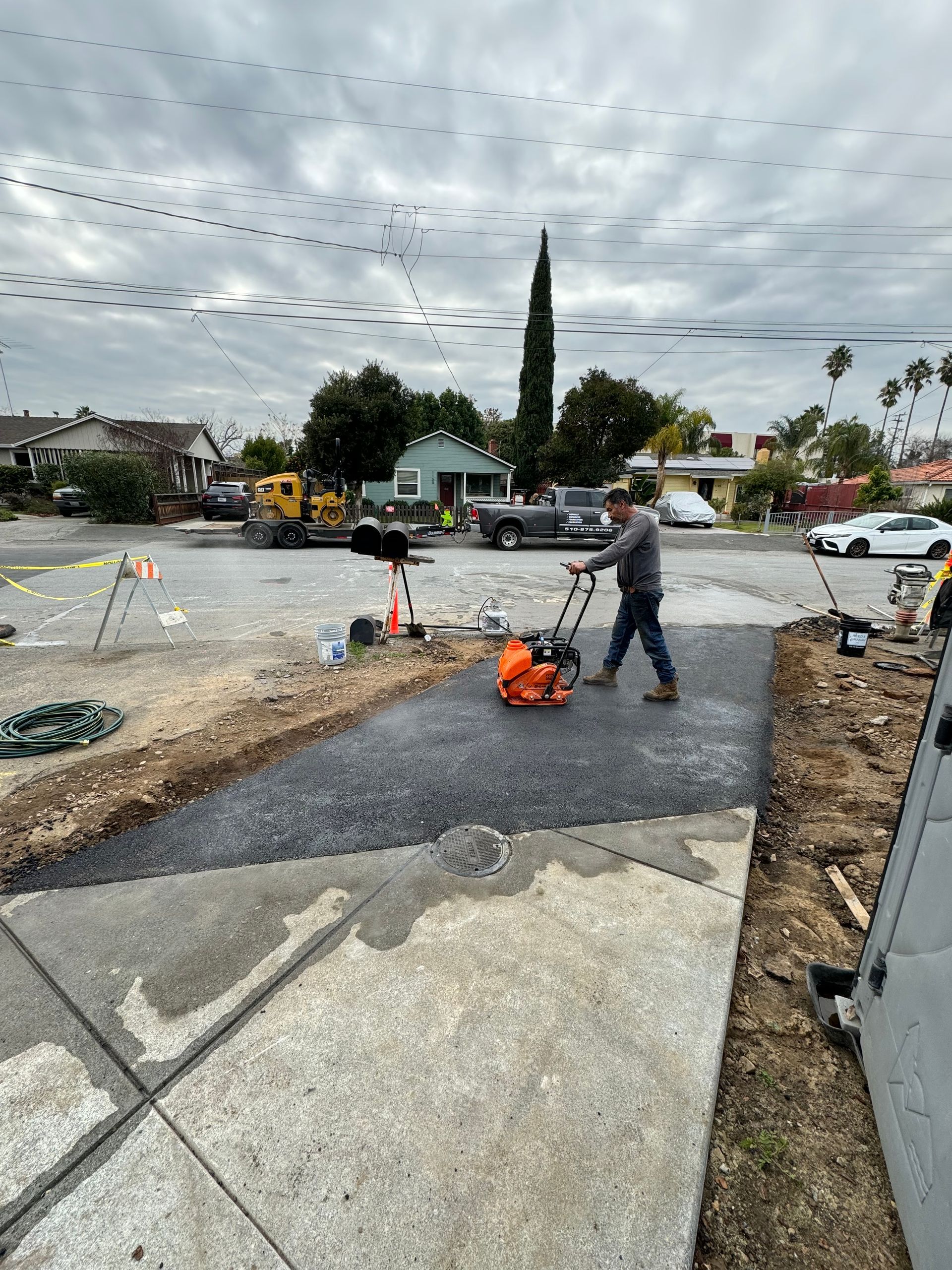 A man is using a machine to level a sidewalk.