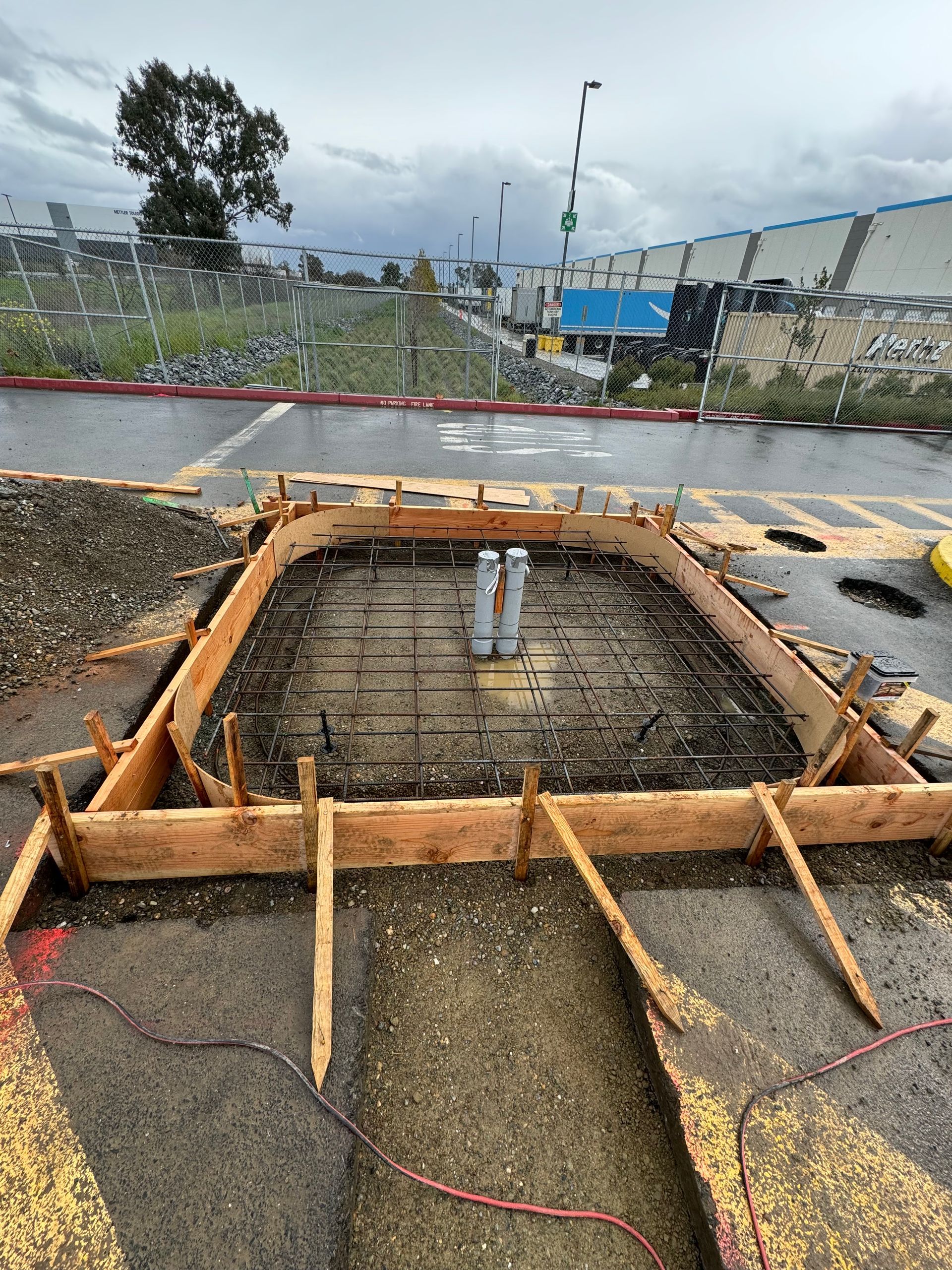 A concrete foundation is being built on the side of a road.