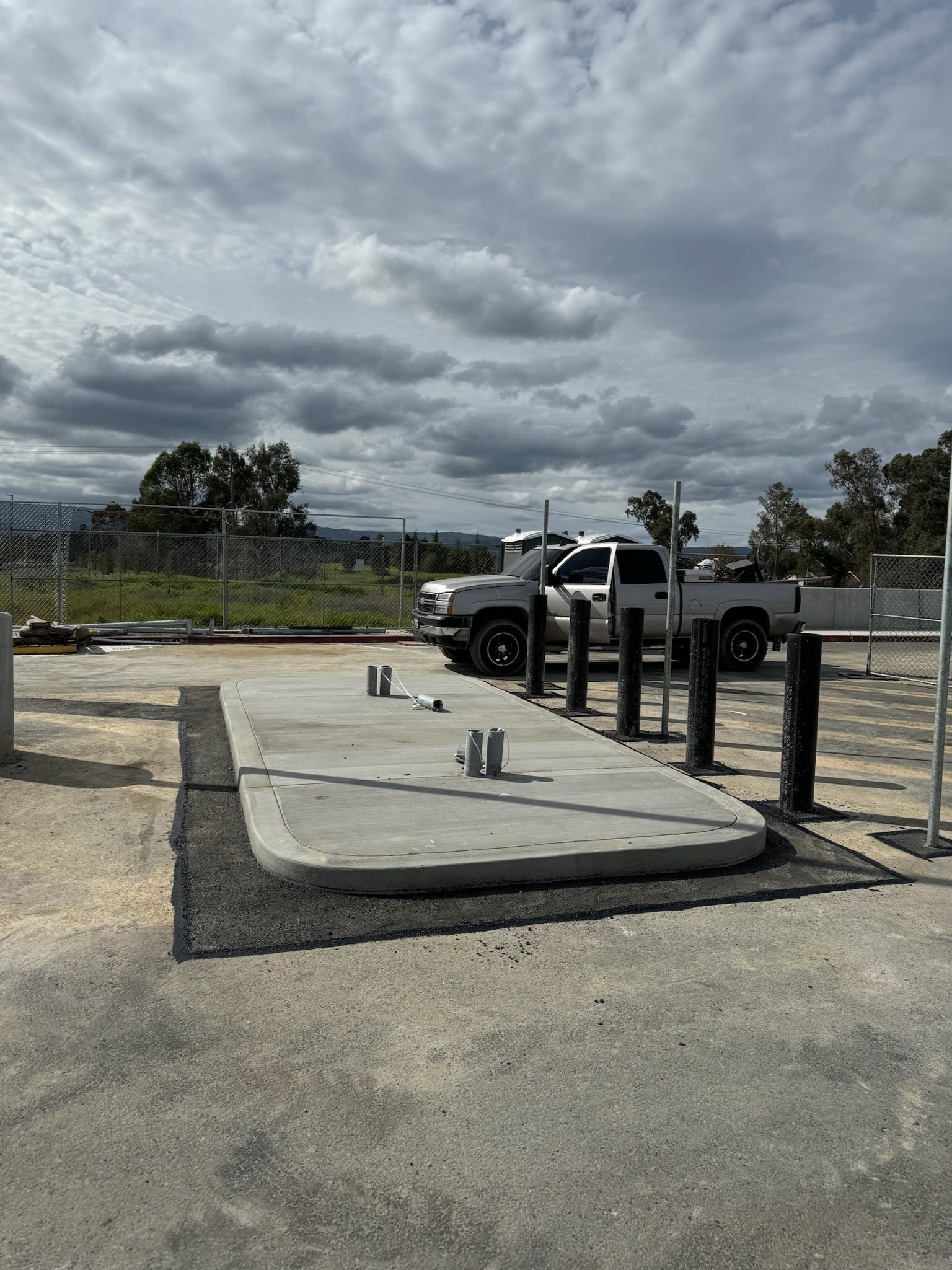 A truck is parked in a parking lot next to a concrete platform.