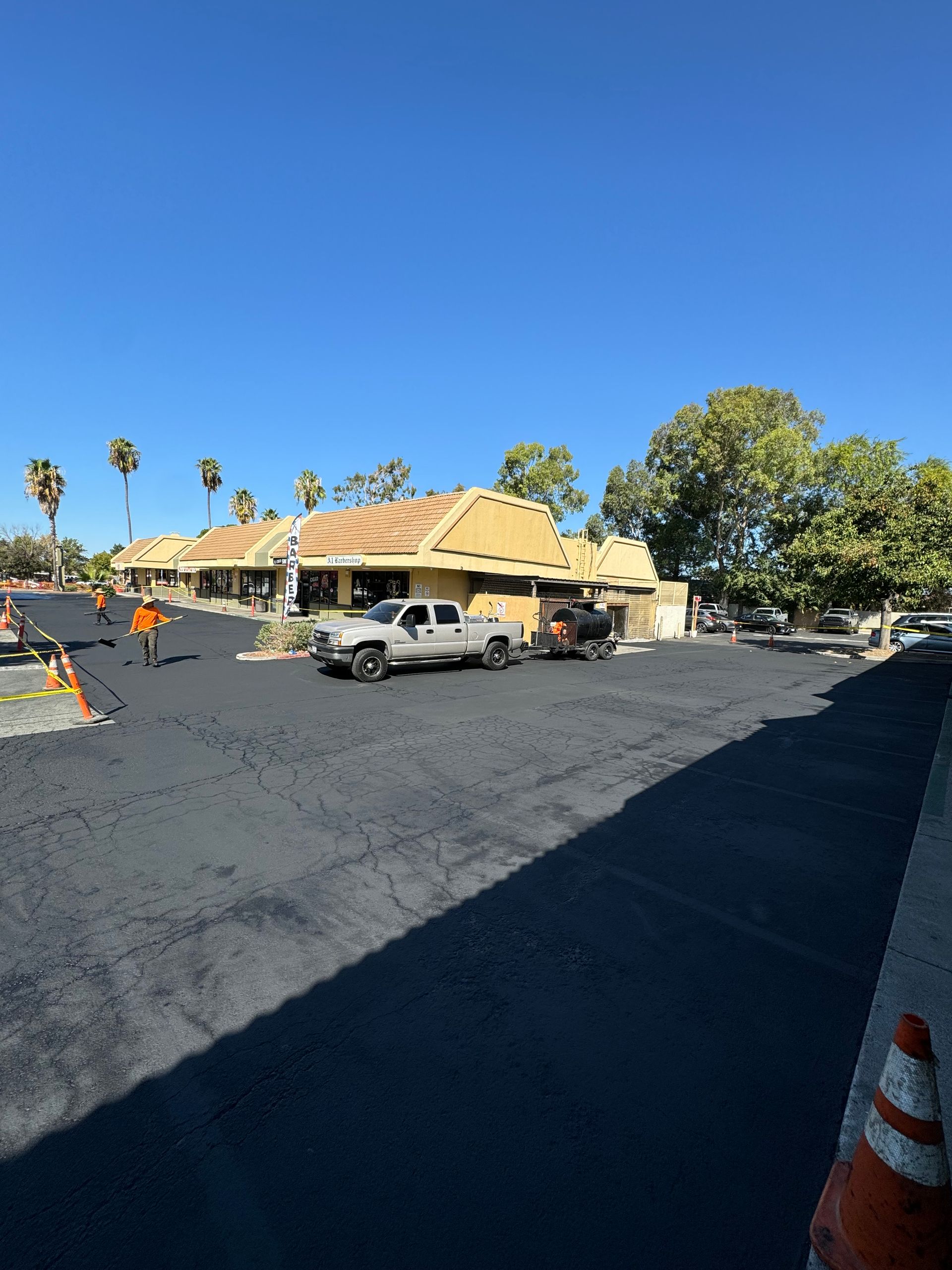 A lot of cars are parked in a parking lot in front of a building.