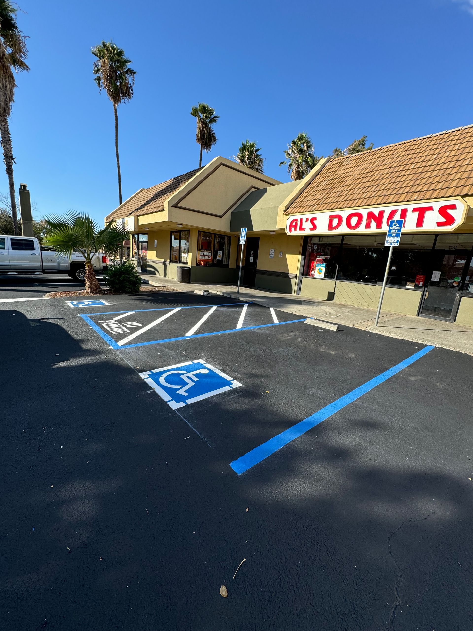 A handicapped parking spot in front of a donut shop
