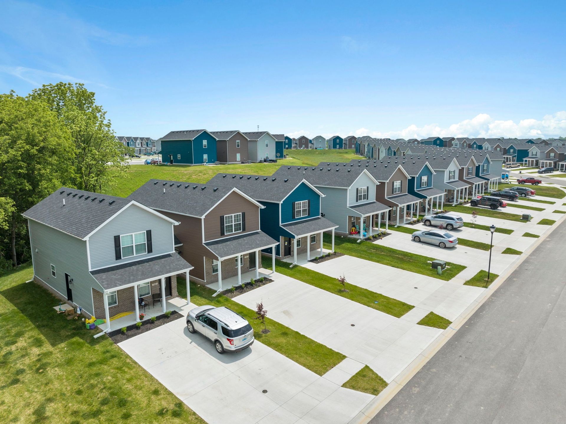 An aerial view of a row of houses with cars parked in front of them.