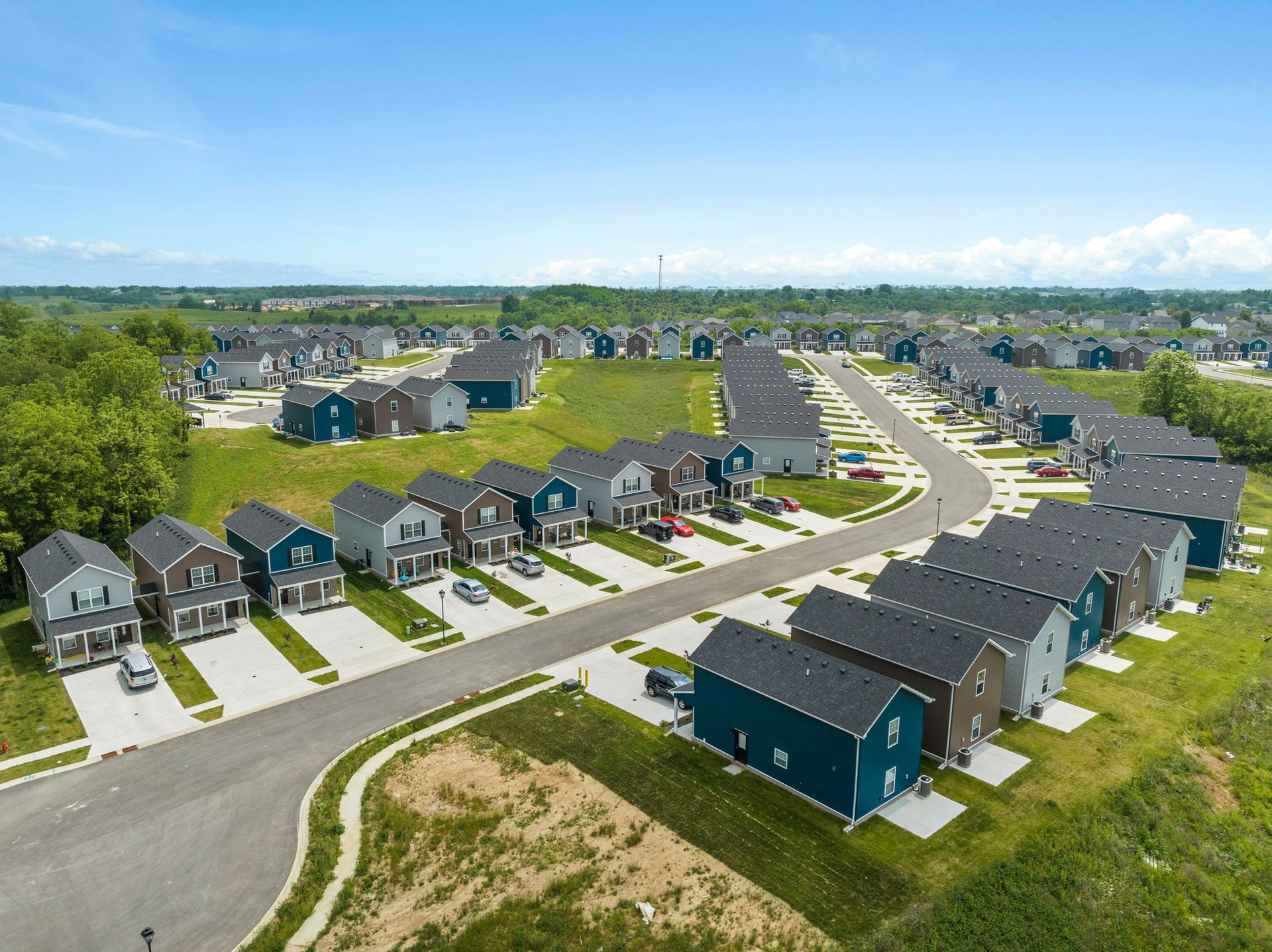 An aerial view of a residential neighborhood with lots of houses and a road.