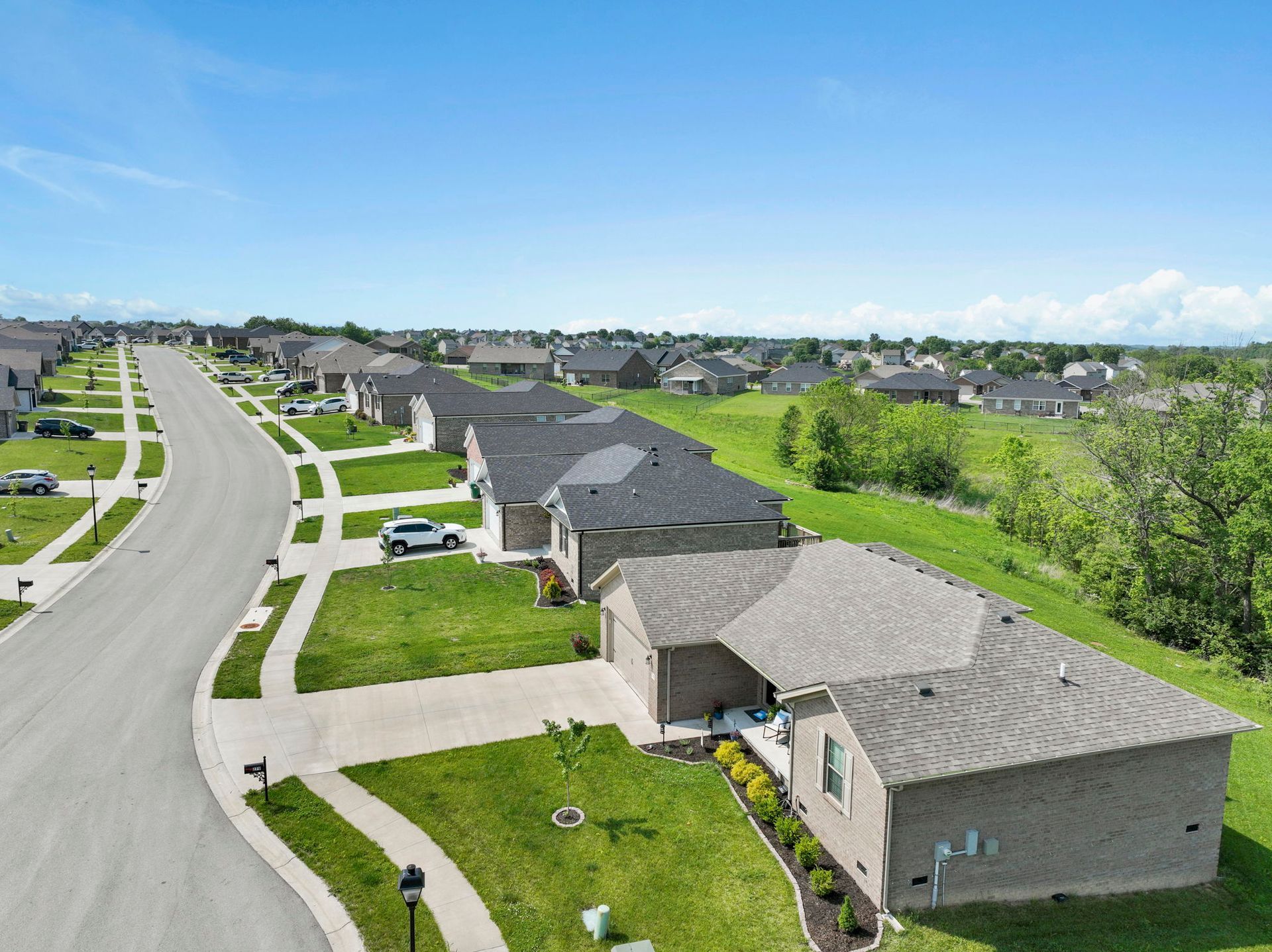 An aerial view of a residential neighborhood with houses and a street.