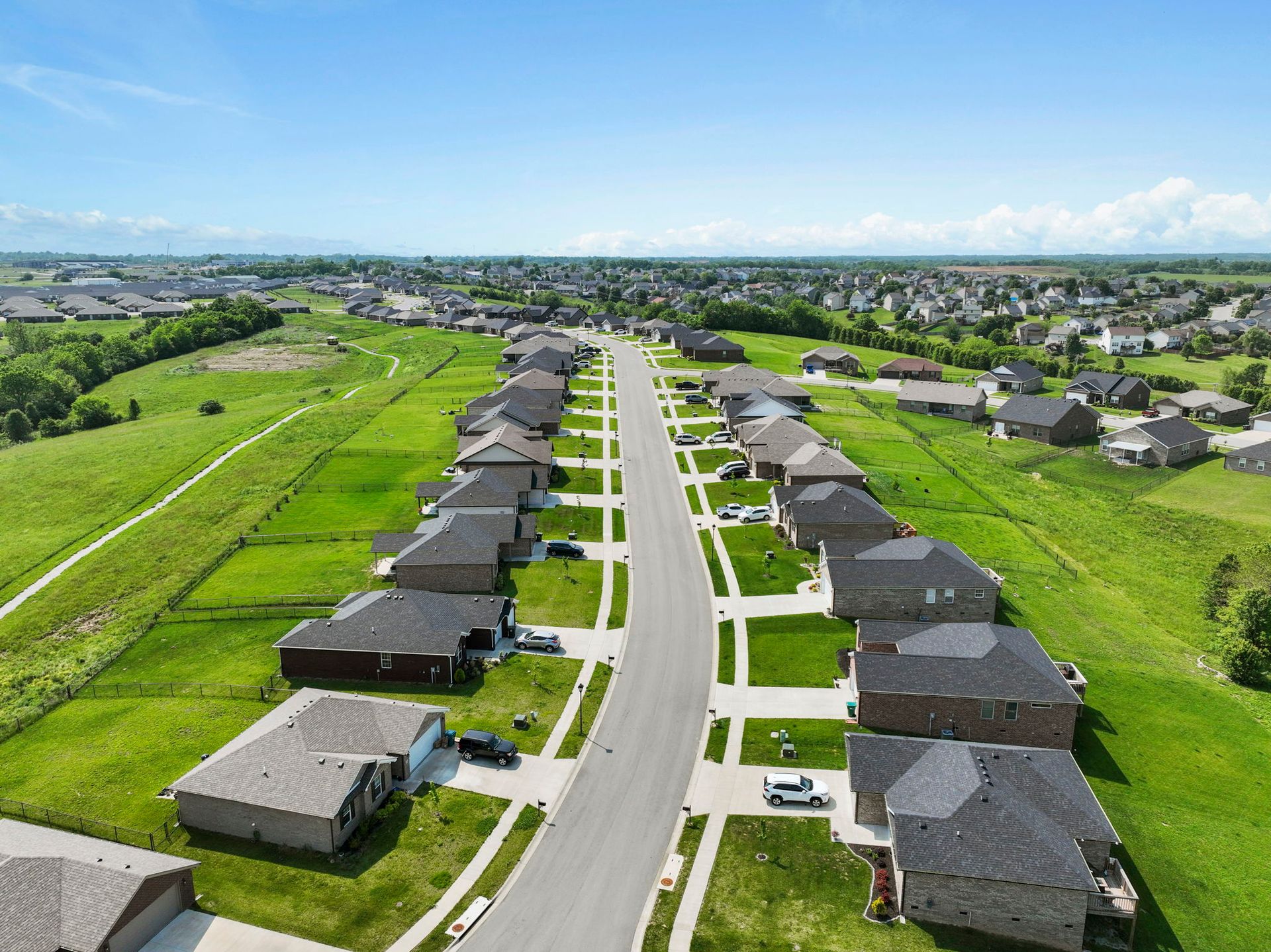 An aerial view of a residential neighborhood with lots of houses and a road.