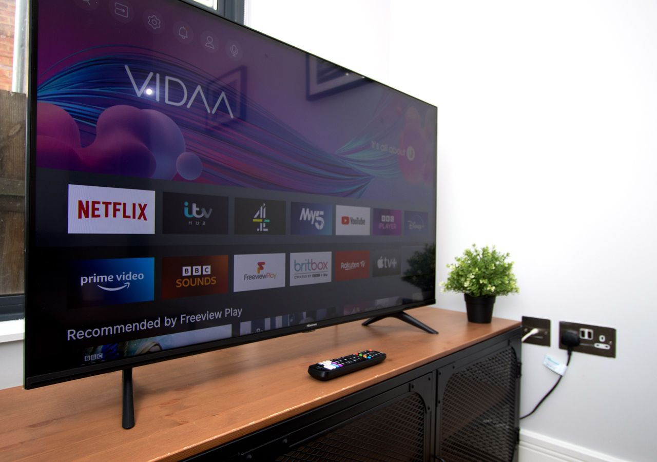 A flat screen tv is sitting on top of a wooden entertainment center.